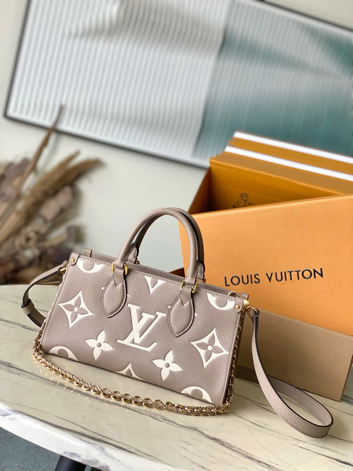 💰1100 (top layer leather) top original order M23641 Elephant Gray This small OnTheGo handbag is Monogram Empreinte leather embossed with the Giant Monogram pattern, highlighting the soft and slender silhouette. The compact interior keeps your daily essentials organized, while the articulated top handle and detachable leather and woven chain shoulder strap allow for a variety of carrying options. Dimensions: 25 × 13 × 10 cm