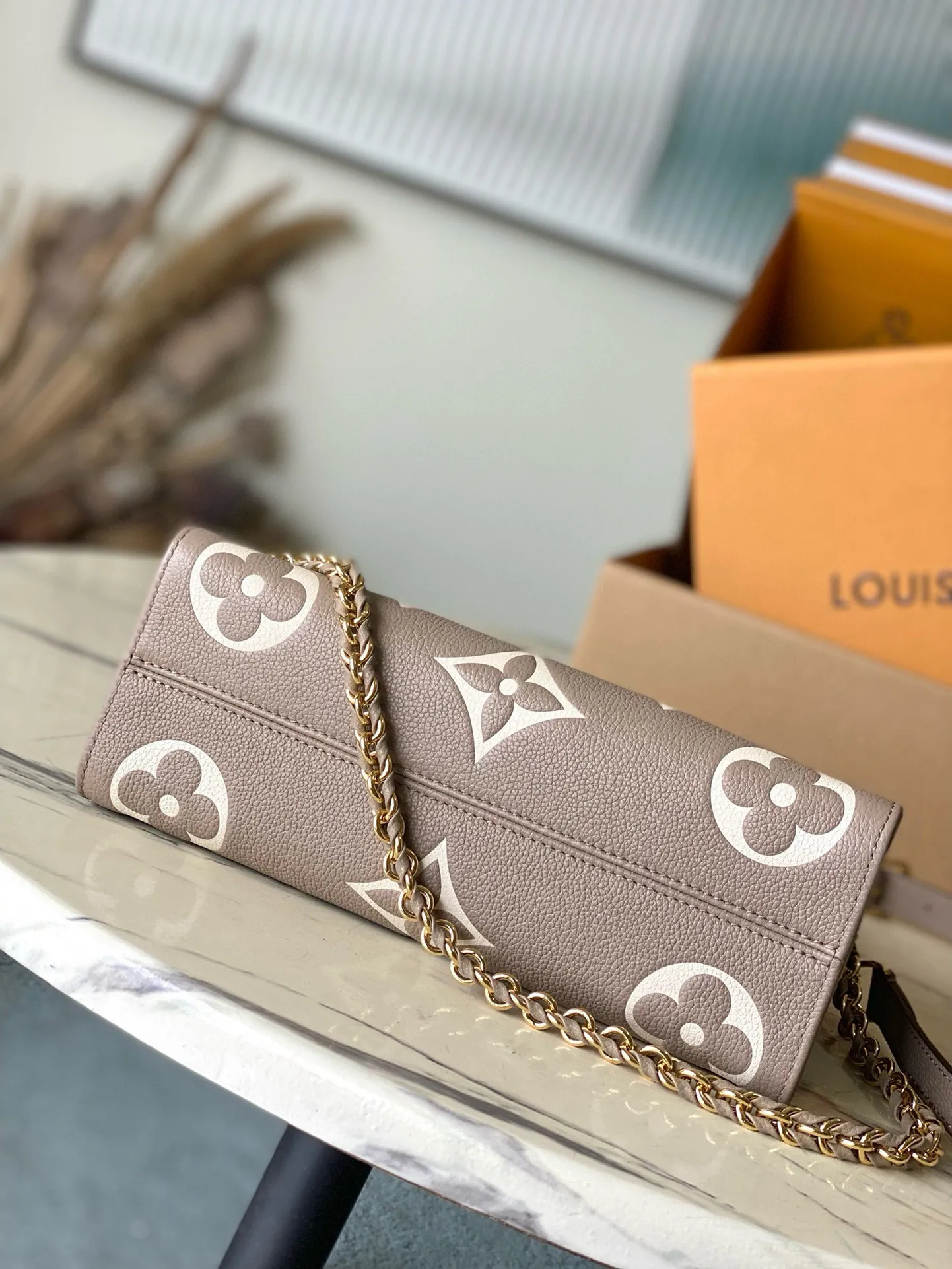 💰1100 (top layer leather) top original order M23641 Elephant Gray This small OnTheGo handbag is Monogram Empreinte leather embossed with the Giant Monogram pattern, highlighting the soft and slender silhouette. The compact interior keeps your daily essentials organized, while the articulated top handle and detachable leather and woven chain shoulder strap allow for a variety of carrying options. Dimensions: 25 × 13 × 10 cm
