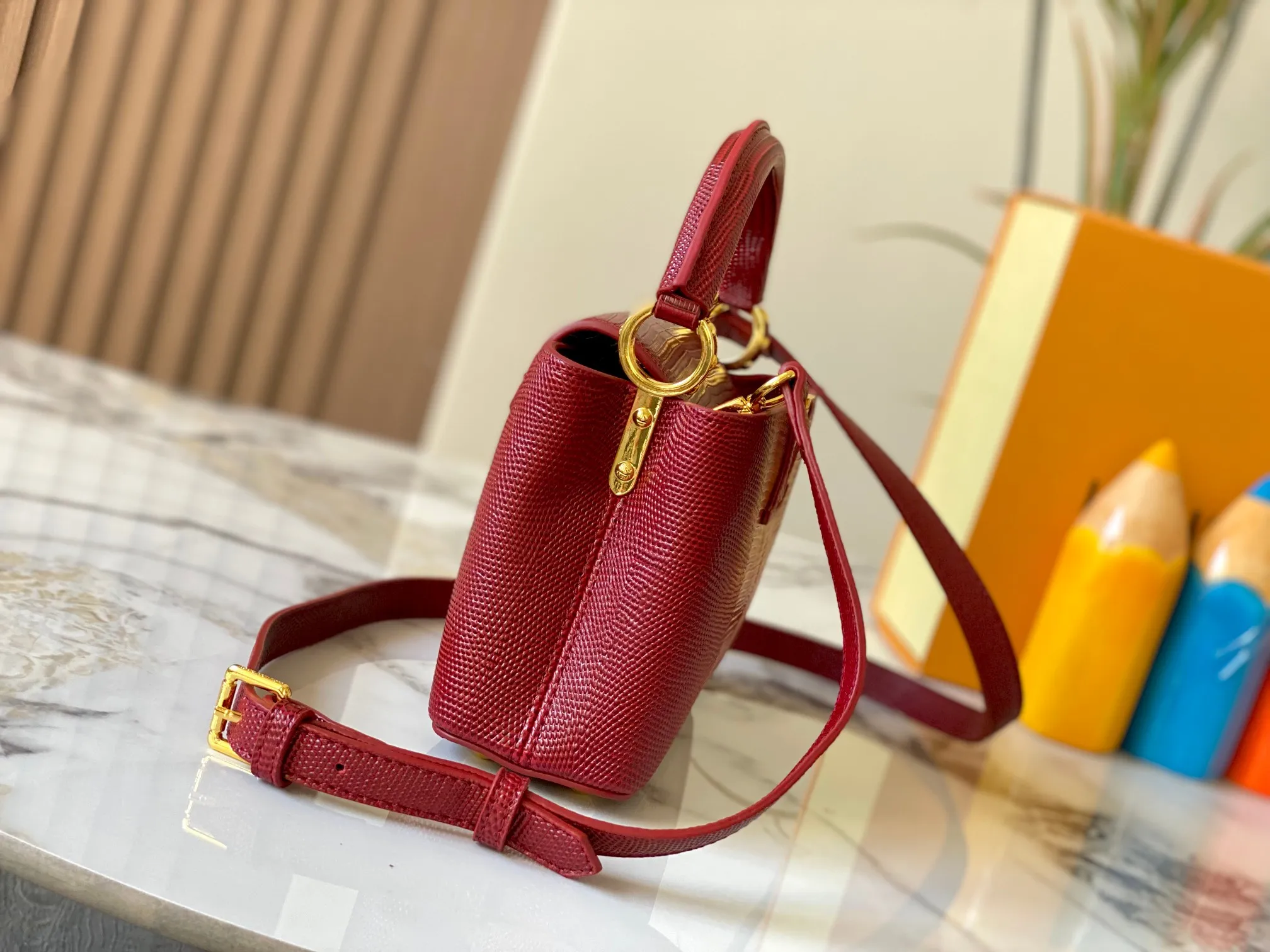 Top original P420 Guangzhou product M99527 maroon lizard gold buckle This Capucines mini handbag is wrapped in gorgeous lizard leather and lined with fine sheepskin, embellished with dazzling metal parts. The flip cover reads LV letters inside, and a Monogram flower blooms when turned out. Its compact size makes it a dazzling choice for evening occasions. Detailed features 21 x 14 x 8 cm (length x height x width)