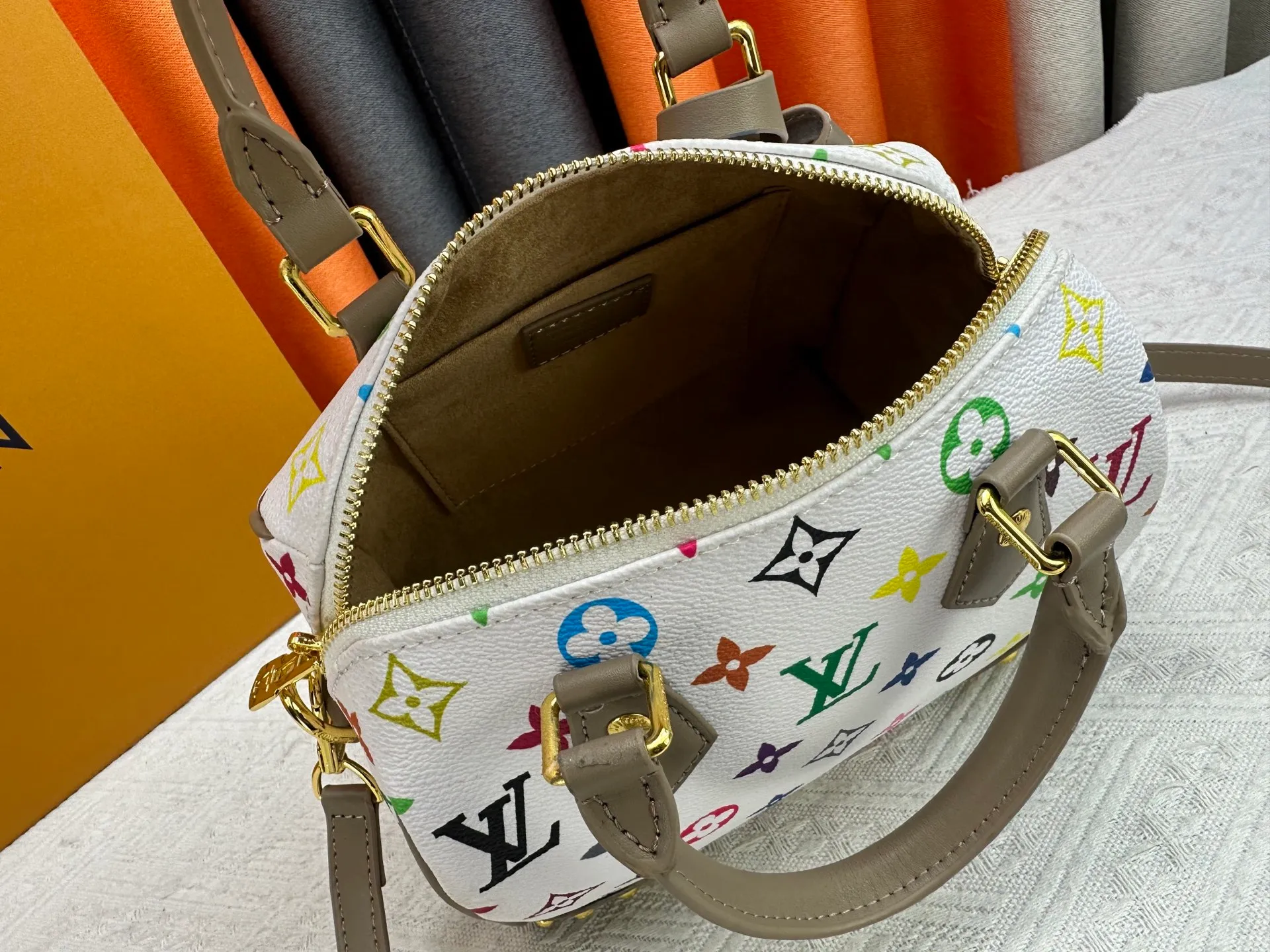 P260 upgraded original M58953 M46234 M46222 Speedy Bandoulière 20 handbag is made of soft coated canvas, and the full-length Monogram pattern is traced in colorful rainbow tones, highlighting the smart style of the Louis Vuitton x Murakami reissue series. The Toron handle and detachable shoulder strap are constructed of cow leather, the metal corners recall classic luggage elements, and the bow-shaped key bag and padlock add brand touches. Dimensions: 20.5 x 13.5 x 12.0 cm (length x height x width)