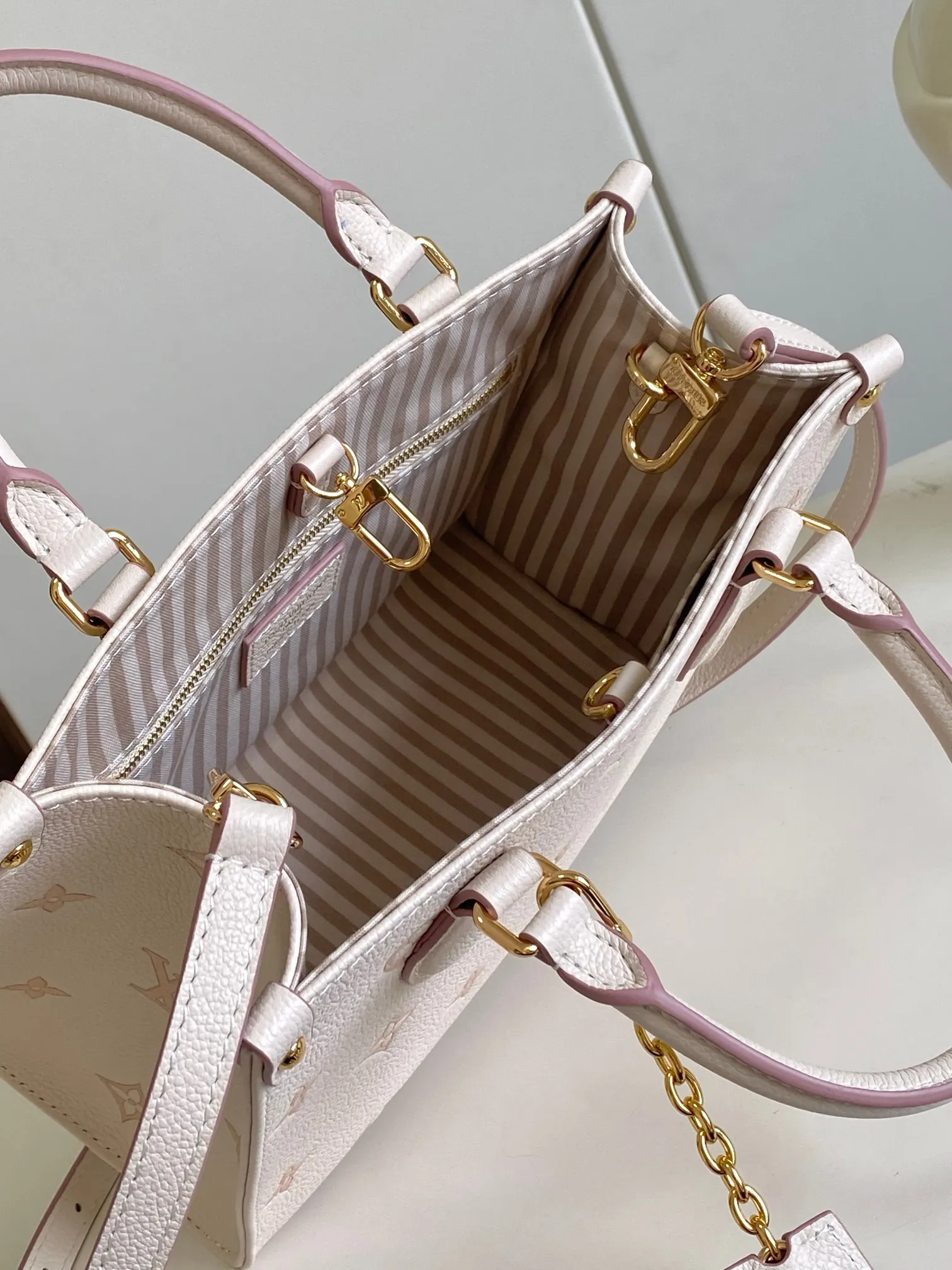 💰1140 (top layer leather) top original single 163 chip [OnTheGo small handbag] M14403 milky apricot color (jacquard) renews the brand's classic Monogram Empreinte leather, using the same tone to outline the pattern. The detachable metal chain decoration highlights the details, the striped fabric lining gives off an elegant atmosphere, and the detachable shoulder strap allows for shoulder or cross-body wear ~ Size 19 x 11.5 x 25cm