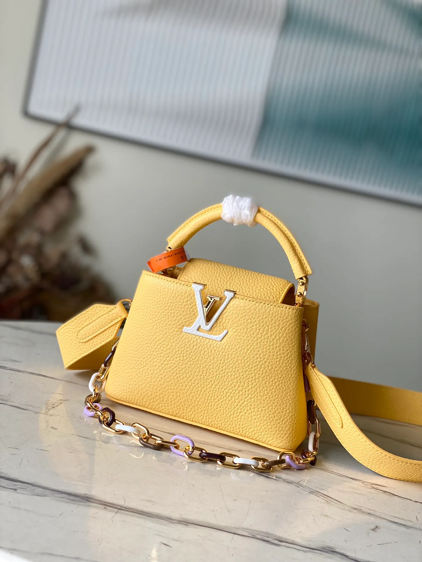 💰2460 (Special Original Leather) M21798 Lemon Yellow Mini This Capucines mini handbag has metal and resin links interlocking with each other, adding a fun detachable chain to the classic design. Taurillon leather has a shiny look, and the logo can be highlighted by placing the flap on the inside. Dimensions: 21 x 14 x 8 cm