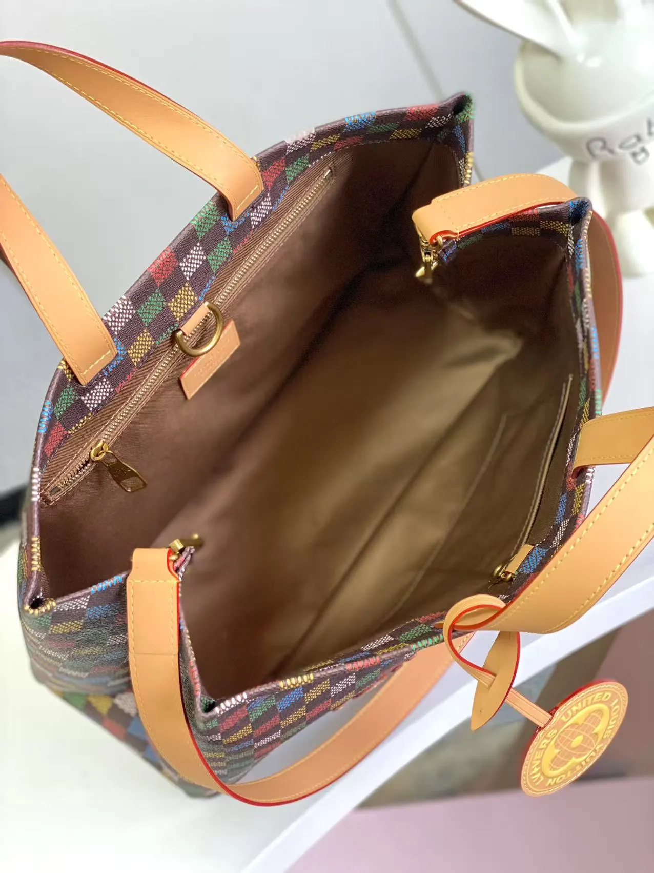 💰1100 Top Original N00192 Shopper Tote handbag design is inspired by Louis Vuitton's classic shopping bag, characterized by the same clean lines and contrasting Louis Vuitton letter logo. Crafted from LVers Damier Ebene coated canvas, this bag features Pharrell Williams' colorful reinterpretation of the Damier pattern (inspired by a classic design created by Georges Vuitton in 1888). Two top handles and a detachable shoulder strap provide a flexible carrying method that combines practicality with unique charm. Dimensions: 32 x 16 x 40 cm
