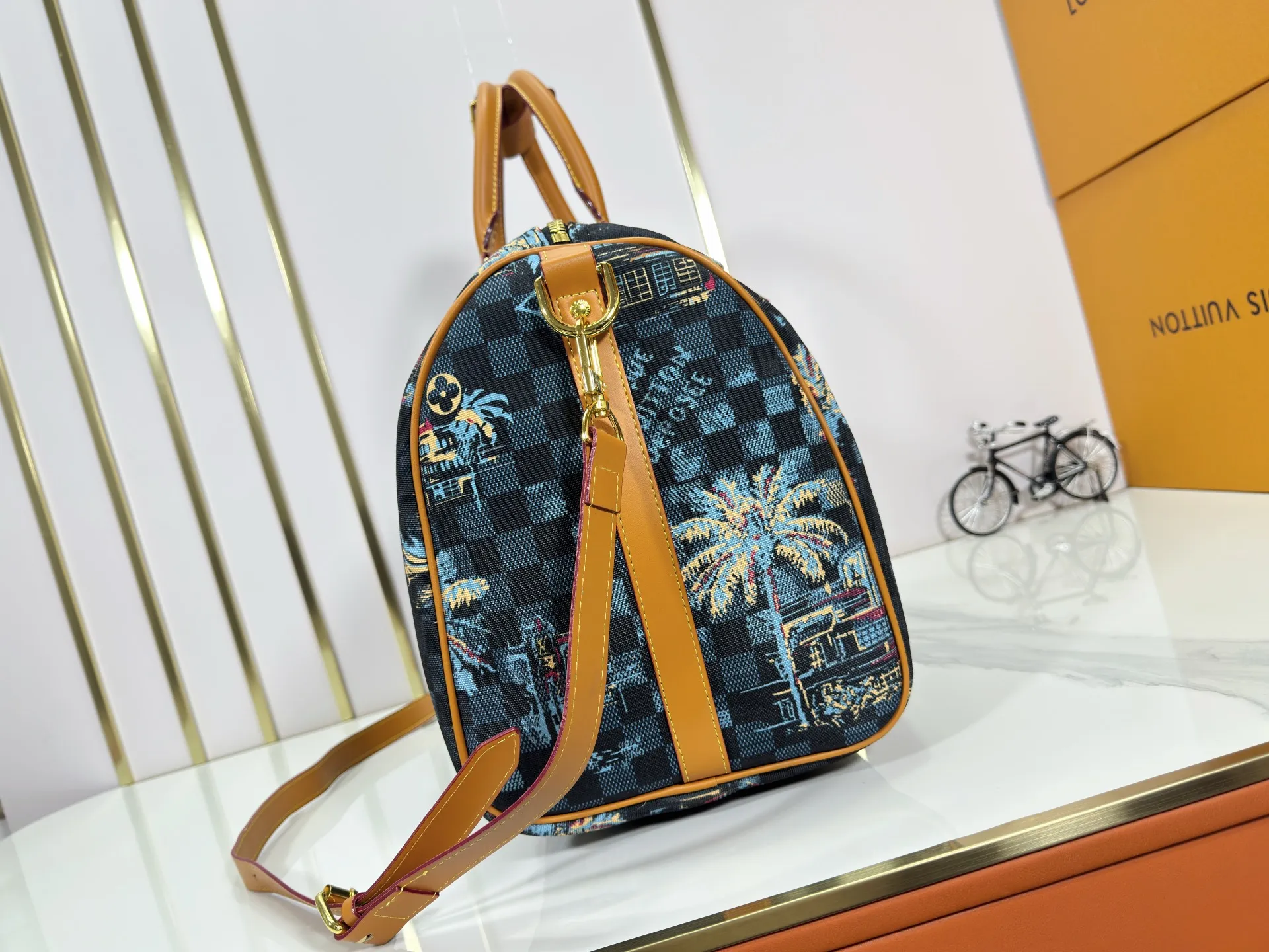 P360 Upgraded Original M00227 Coconut Tree This Keell Bandoulière 50 travel bag is made of gorgeous cotton with Damier lm Trees jacquard texture, showing the brand's exquisite craftsmanship. The checkerboard pattern highlights palm trees, iconic buildings and vintage car patterns, recalling the Miami night scene depicted in old postcards, and the Marque L.Vuitton Désée logo is subtly integrated into it.  29 x 23 x 50 cm (H x W x Length) Damier lm Trees Jacquard cotton Cow leather trim Fabric lining Metal hardware Carry-on baggage dimensions Double zipper closure Padlock Removable name tag Internal zippered pocket Shoulder straps: removable, adjustable Strap half-length: 36.0 cm Strap half-length adjustable to: 50.0 cm Handle: Double handle