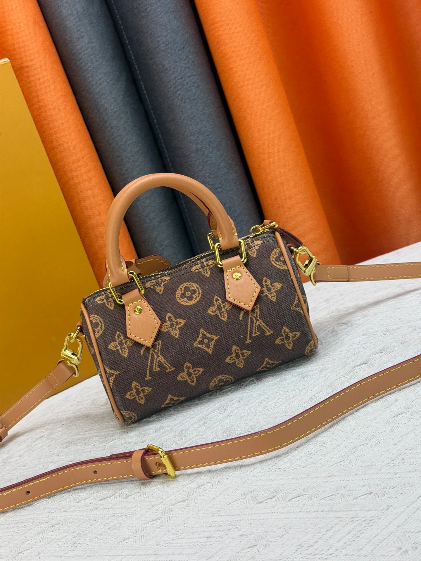 P220 M28322 Red M28323 M27610 M81085 [Exclusive background shot] This Nano Speedy handbag condenses the configuration of Louis Vuitton's classic Speedy handbag. It is made of Monogram canvas with distressed cow leather details and dazzling metal parts, making it easy to carry with you every day. The handles and removable and adjustable shoulder strap allow for a variety of styling possibilities. 16.0 x 10.0 x 7.5 cm (L x H x W) • Monogram coated canvas • Cow leather trim • Metal hardware • Zipper closure • Space to store daily necessities such as a 6.1-inch smartphone, card holder and lipstick • Shoulder strap: removable, adjustable • Half-length strap: 45.5 cm • Half-length strap adjustable to: 54.0 cm • Handle: Double handle