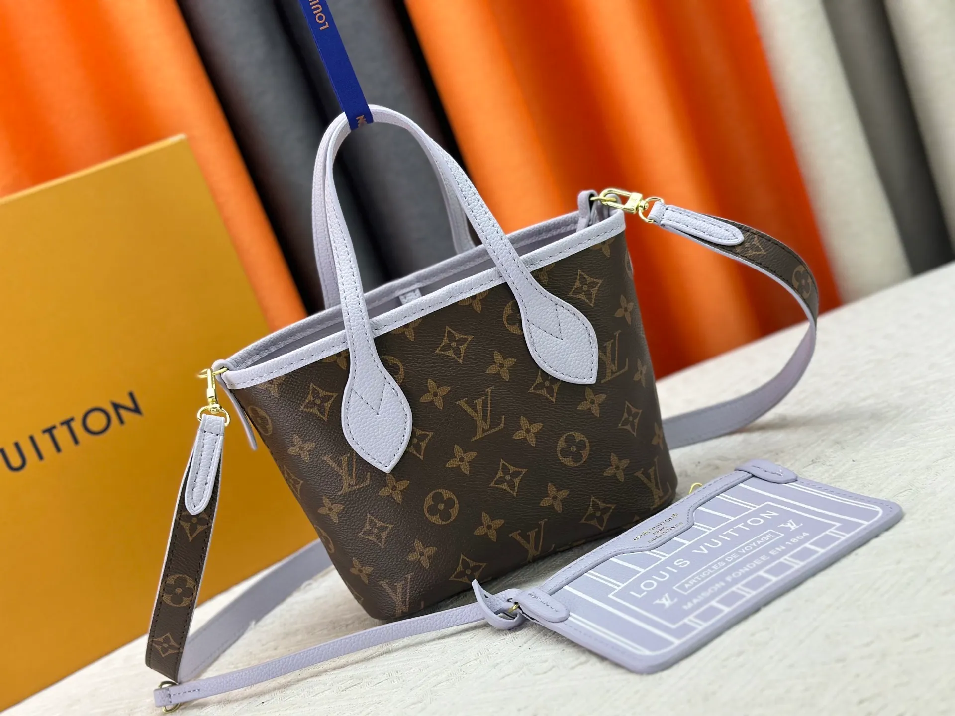 P240 M25656 M12099 Upgraded original Neverfull Bandouliere Inside Out BB handbag is a double-sided version of the classic design this season, with the front and back decorated with iconic Monogram canvas and grained leather. The removable zipper bag can be used alone or hung externally. The detachable shoulder strap makes it easy to wear cross-body, and the dazzling metal hardware adds a sophisticated detail. Dimensions: 26.5 × 16.5 × 11 cm