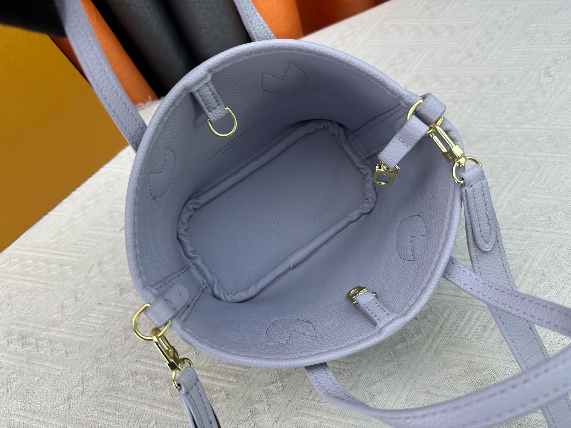 P240 M25656 M12099 Upgraded original Neverfull Bandouliere Inside Out BB handbag is a double-sided version of the classic design this season, with the front and back decorated with iconic Monogram canvas and grained leather. The removable zipper bag can be used alone or hung externally. The detachable shoulder strap makes it easy to wear cross-body, and the dazzling metal hardware adds a sophisticated detail. Dimensions: 26.5 × 16.5 × 11 cm