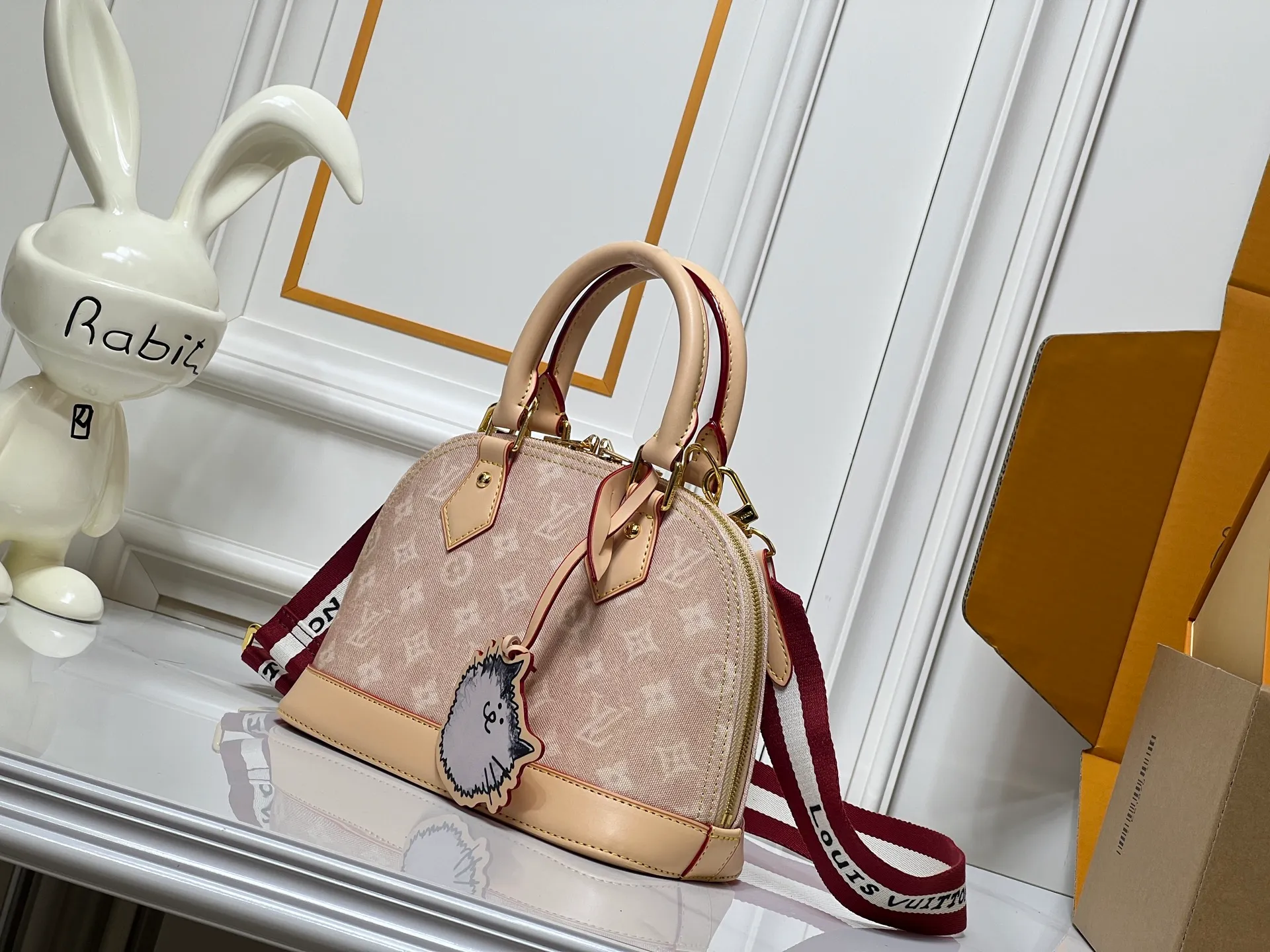 Batch 300💰Alma BB handbag M99021 M82348 A creative work of Louis Vuitton's Catogram series, the Alma BB handbag is made of light beige denim and engraved with the brand's iconic Monogram pattern, showing a retro style. Paired with beige leather trim and gold hardware, the classic shell bag shape incorporates cute cat charms, injecting vitality into the overall look. Equipped with a detachable shoulder strap, it can be carried by hand or cross-body to meet a variety of dressing needs. From daily outings to casual luxury socializing, it combines retro texture and cute design to become an eye-catching item that shows personality and taste. It is a fashionable choice for those who love cute style and classic design. Size: 23.5x17x11cm