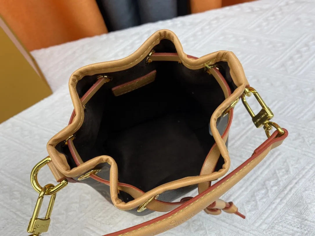P160 Upgraded original M46291 M46449 M81266 gray, black (embossed silk screen) This Nano Noé handbag is made of Monogram Empreinte leather with embossed Monogram pattern, interpreting the pocket version of the classic Noé handbag, with a trendy drawstring to store daily needs. The handle and adjustable shoulder strap are both detachable, enabling a variety of carrying methods. Dimensions: 13 x 16 x 10 cm