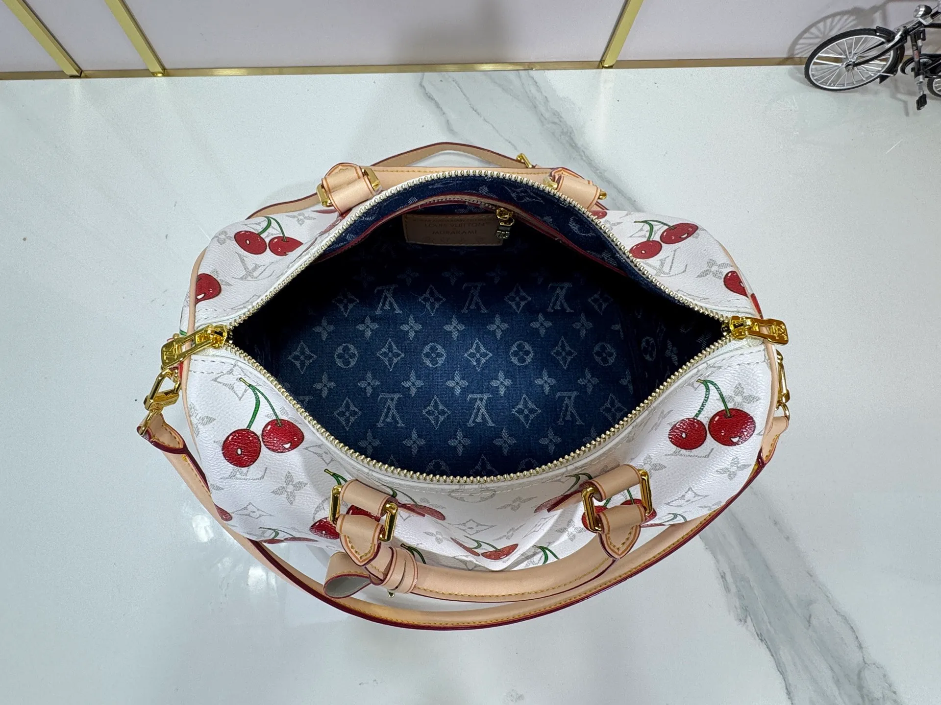 P300 M14328 Upgraded original version This Speedy Soft 30 handbag Murakami series Monogram Dune element pays tribute to the design of Gaston Louis Vuitton collection series. The long handle makes it easy to carry on the shoulder, making it a great travel companion. 30.0 x 21.0 x 17.0 cm (L x H x W) • Coated canvas • Cow leather trim • Metal hardware • Double zipper closure • Internal zippered pocket • Key holder • Patch name tag • Airplane style decoration • Holds 9" tablet, 6.7" smart phone, Ziy long wallet, keys, tissues, and sun • Shoulder strap: removable, non-adjustable • Strap half length: 24.0 cm • Handle: Double handle