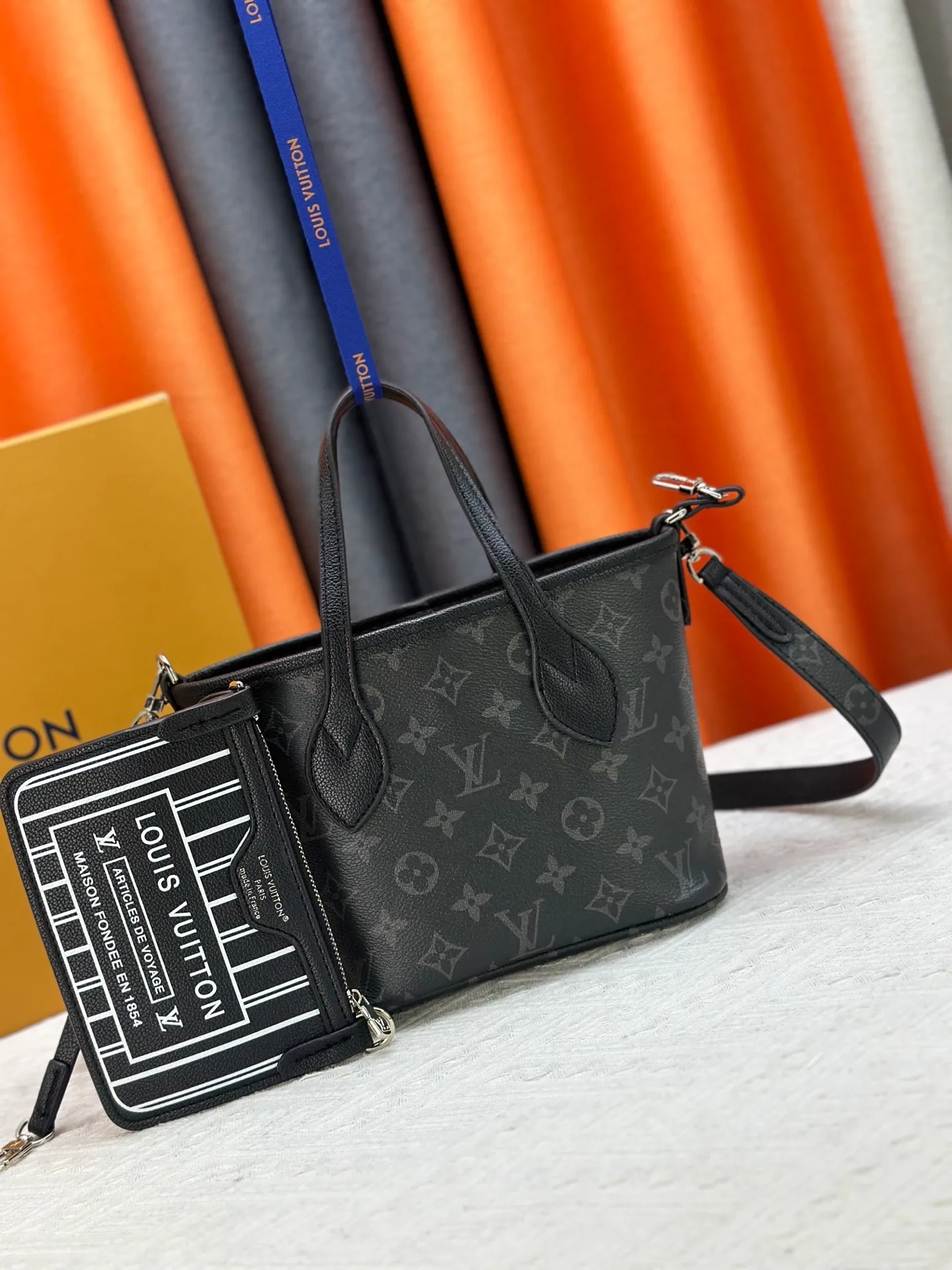 P240 M25656 M12099 Upgraded original Neverfull Bandouliere Inside Out BB handbag is a double-sided version of the classic design this season, with the front and back decorated with iconic Monogram canvas and grained leather. The removable zipper bag can be used alone or hung externally. The detachable shoulder strap makes it easy to wear cross-body, and the dazzling metal hardware adds a sophisticated detail. Dimensions: 26.5 × 16.5 × 11 cm