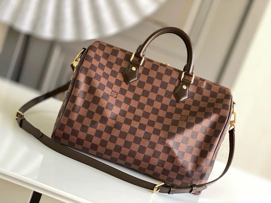 💰840 (size 35) Top original N41366 SPEEDY 35 handbag (with shoulder strap) The Speedy 35 handbag made of Damier Ebène canvas has a classic shape and exudes timeless elegance. The multifunctional shoulder strap can be used to carry it by hand, on the shoulder or across the body, making it flexible and convenient. Detailed features 35 x 23 x 18 cm (Length x Height x Width) Smooth leather trim Shiny gold-tone brass hardware Double zip closure with padlock Internal pocket D-ring for keys and accessories Soft fabric lining Shoulder strap: Removable, adjustable Half-length strap: 47.0 cm Half-length strap adjustable to: 53.5 cm Handle: Double handle
