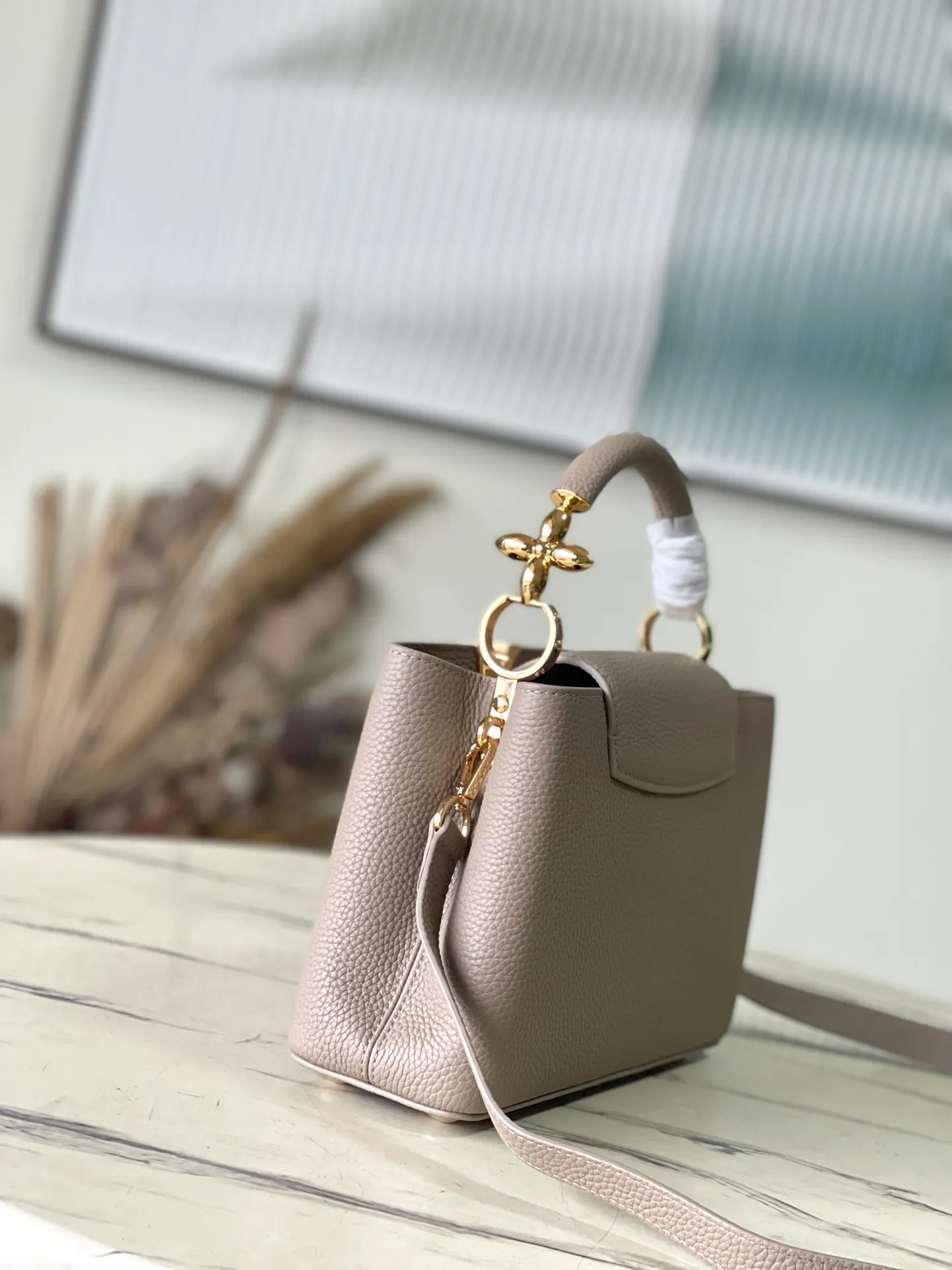 💰2360 (Special Grade Original Leather) M24698 Elephant Gray Small Size This Capucines BB handbag is made of Taurillon cow leather embellished with shiny metal parts, and the LV letters are written with 3D strokes. Metal Monogram flowers bloom quietly on the rolled leather handle, subtly proving the brand's exquisite craftsmanship. The detachable and adjustable leather shoulder strap allows for comfortable shoulder carrying. Dimensions: 26.5 × 17.5 × 9 cm
