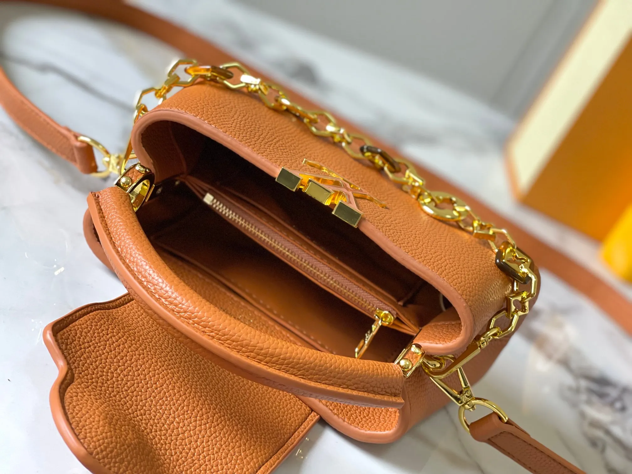 p460 [Guangzhou top quality original] M14393 brown CapucinesEastWest mini handbag, using a decorative chain to show the inspiration of Monogram flowers. Taurillon cow leather creates an exquisite structure, and the LV letters interpret the colorful brushstrokes of the Puffygram jewelry series. The flap can be folded in or out, and the inner pocket can safely store valuables. Size:22×12×8cm