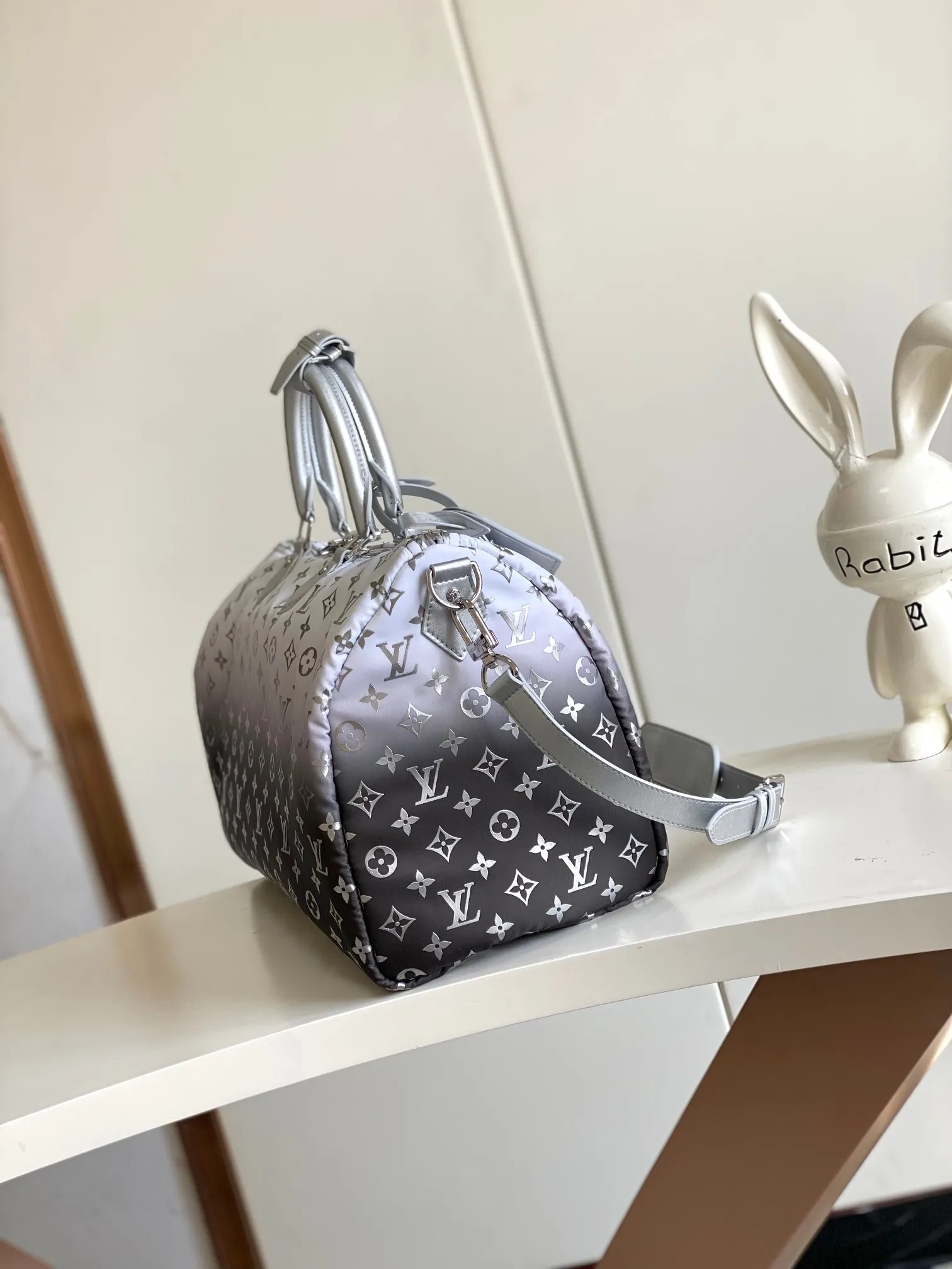 💰1260 Top original single dynamic chip M12067 silver This Keepall Bandoulière 45 travel bag is made of gradient effect Monogram nylon, with plain leather Monogram flower decoration to set off the winter mood. Durable and soft recycled nylon creates a close-fitting design, and the detachable leather strap allows for easy shoulder or cross-body wear.  27 cm