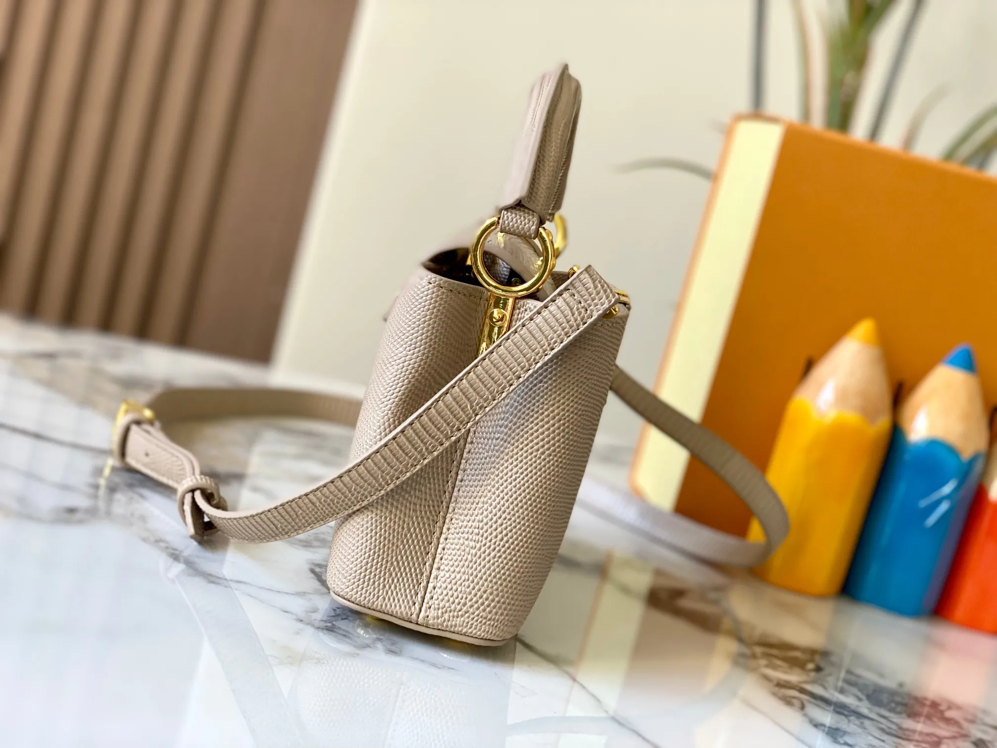 Top original P420 Guangzhou product M99527 apricot lizard gold buckle This Capucines mini handbag is wrapped in gorgeous lizard leather and lined with fine sheepskin, embellished with dazzling metal parts. The flip cover reads LV letters inside, and a Monogram flower blooms when turned out. Its compact size makes it a dazzling choice for evening occasions. Detailed features 21 x 14 x 8 cm (length x height x width)