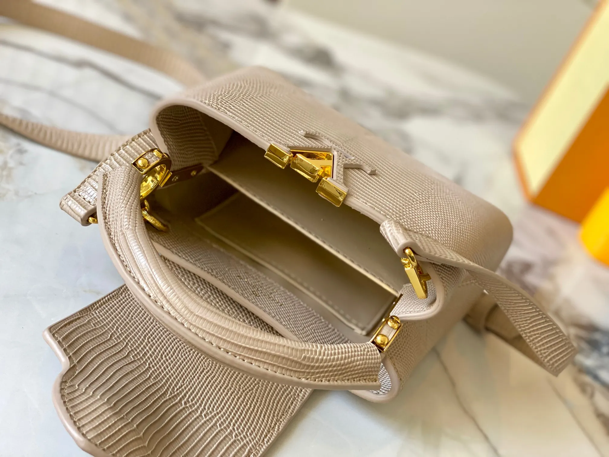 Top original P420 Guangzhou product M99527 apricot lizard gold buckle This Capucines mini handbag is wrapped in gorgeous lizard leather and lined with fine sheepskin, embellished with dazzling metal parts. The flip cover reads LV letters inside, and a Monogram flower blooms when turned out. Its compact size makes it a dazzling choice for evening occasions. Detailed features 21 x 14 x 8 cm (length x height x width)