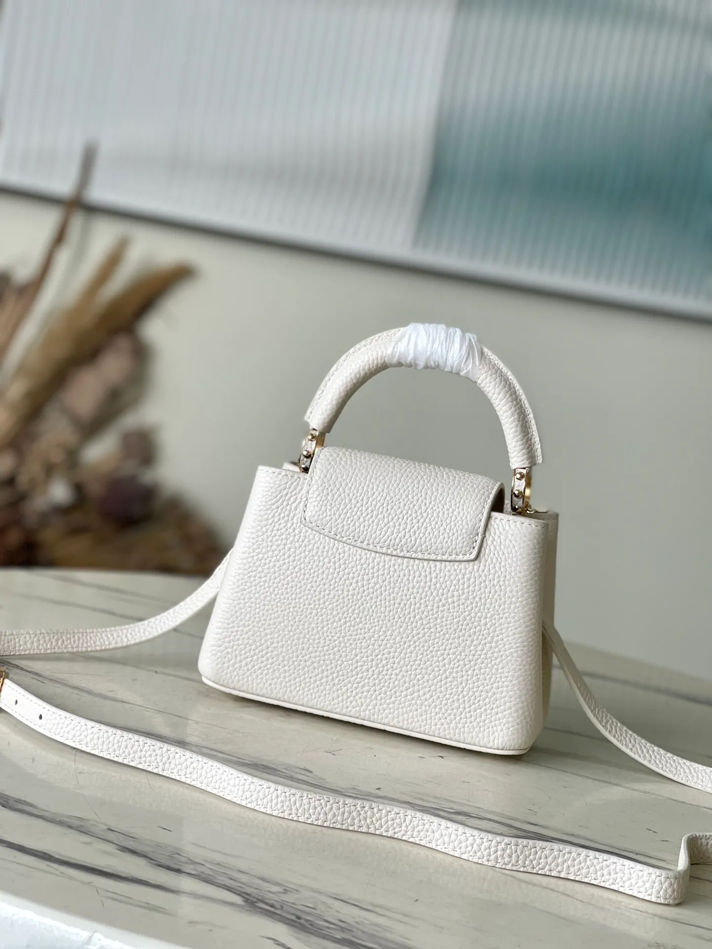 💰2160 (Special grade original leather) M23331/M48865 White with white mother-of-pearl corolla This Capucines Flower Crown handbag is made of full-grain Taurillon leather and is embellished with Monogram flowers. Each flower is made of exquisite shells. The LV logo and flowers echo each other, giving this feminine handbag a jewel-like luster. Use the detachable shoulder strap cleverly to carry it cross-body. Size: 21 * 14*8cm