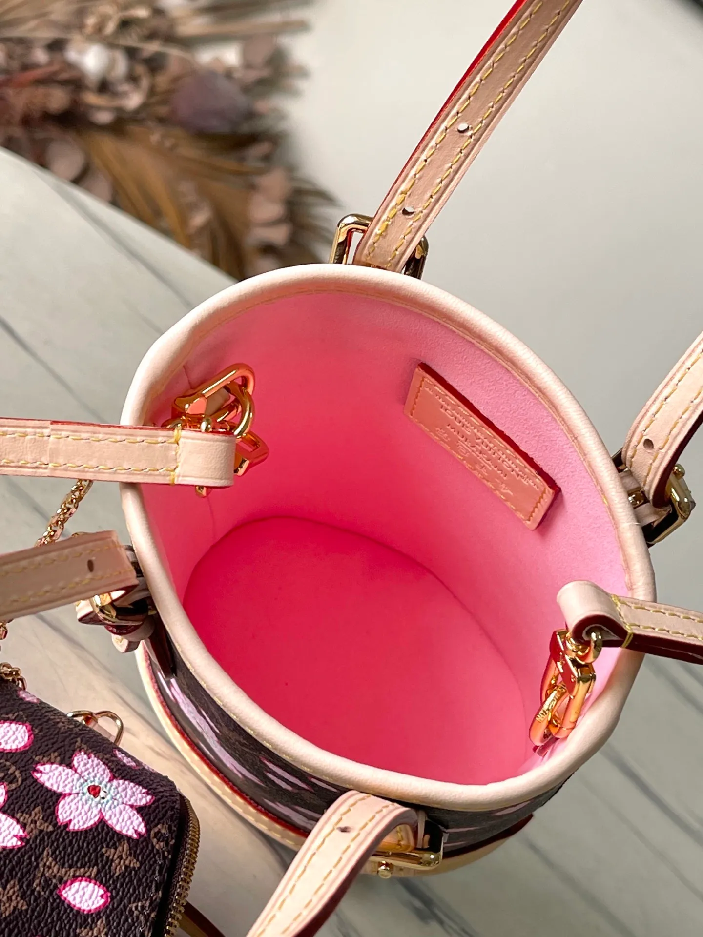 💰900 Top Original Order M13417 This Nano Bucket handbag is made of classic Monogram coated canvas and has a sophisticated design, with cow leather trim and dazzling metal parts to complete the whole. The Cherry Blossom pattern on the body of the bag conveys the atmosphere of prosperous recovery and highlights the distinctive style of Japanese artist Takashi Murakami. The detachable shoulder strap allows for a variety of carrying options, and the leather keychain adds a functional detail. Dimensions: 13 × 17 × 9 cm