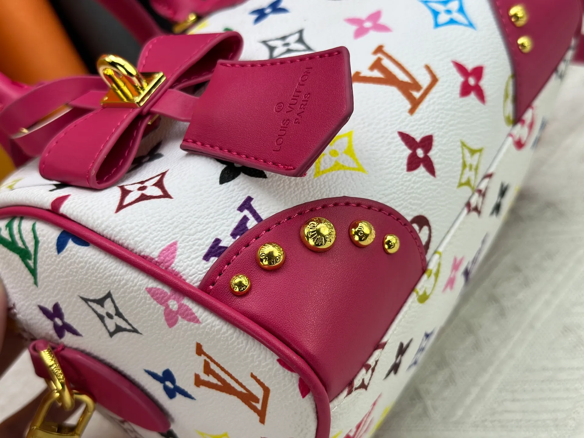 P260 upgraded original M58953 M46234 M46222 Speedy Bandoulière 20 handbag is made of soft coated canvas, and the full-length Monogram pattern is traced in colorful rainbow tones, highlighting the smart style of the Louis Vuitton x Murakami reissue series. The Toron handle and detachable shoulder strap are constructed of cow leather, the metal corners recall classic luggage elements, and the bow-shaped key bag and padlock add brand touches. Dimensions: 20.5 x 13.5 x 12.0 cm (length x height x width)