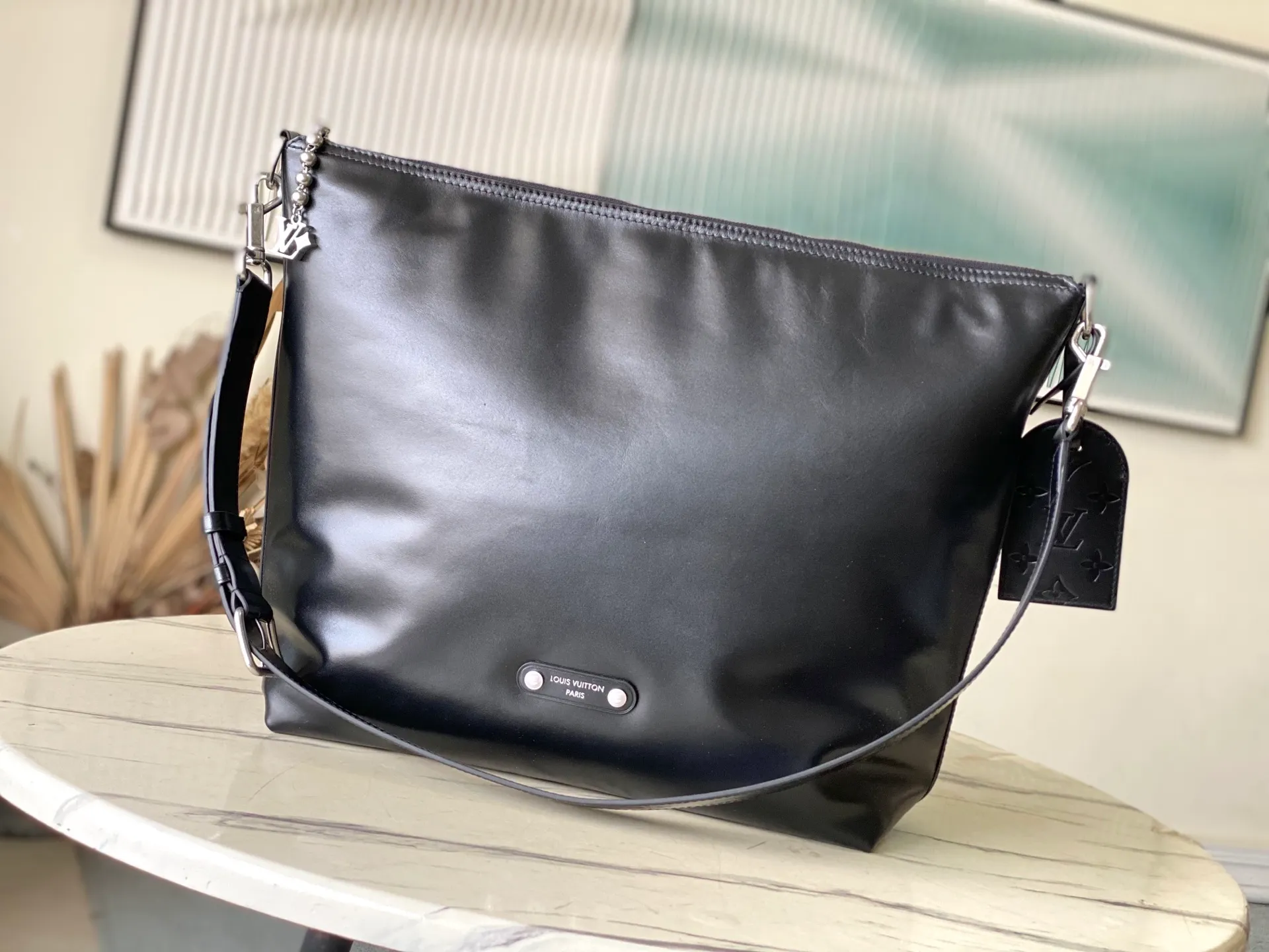💰1280 (top-grain leather) top original order M13986 This Vagabond Hobo handbag is made of glossy soft cow leather to create an ergonomic and close-fitting silhouette. Whether it is worn cross-body or on the shoulder, it can show its cool style. The metal zipper enables smooth opening and closing, and the bead chain cleverly connects the zipper puller and V letter decoration. Dimensions: 35×12×38 cm