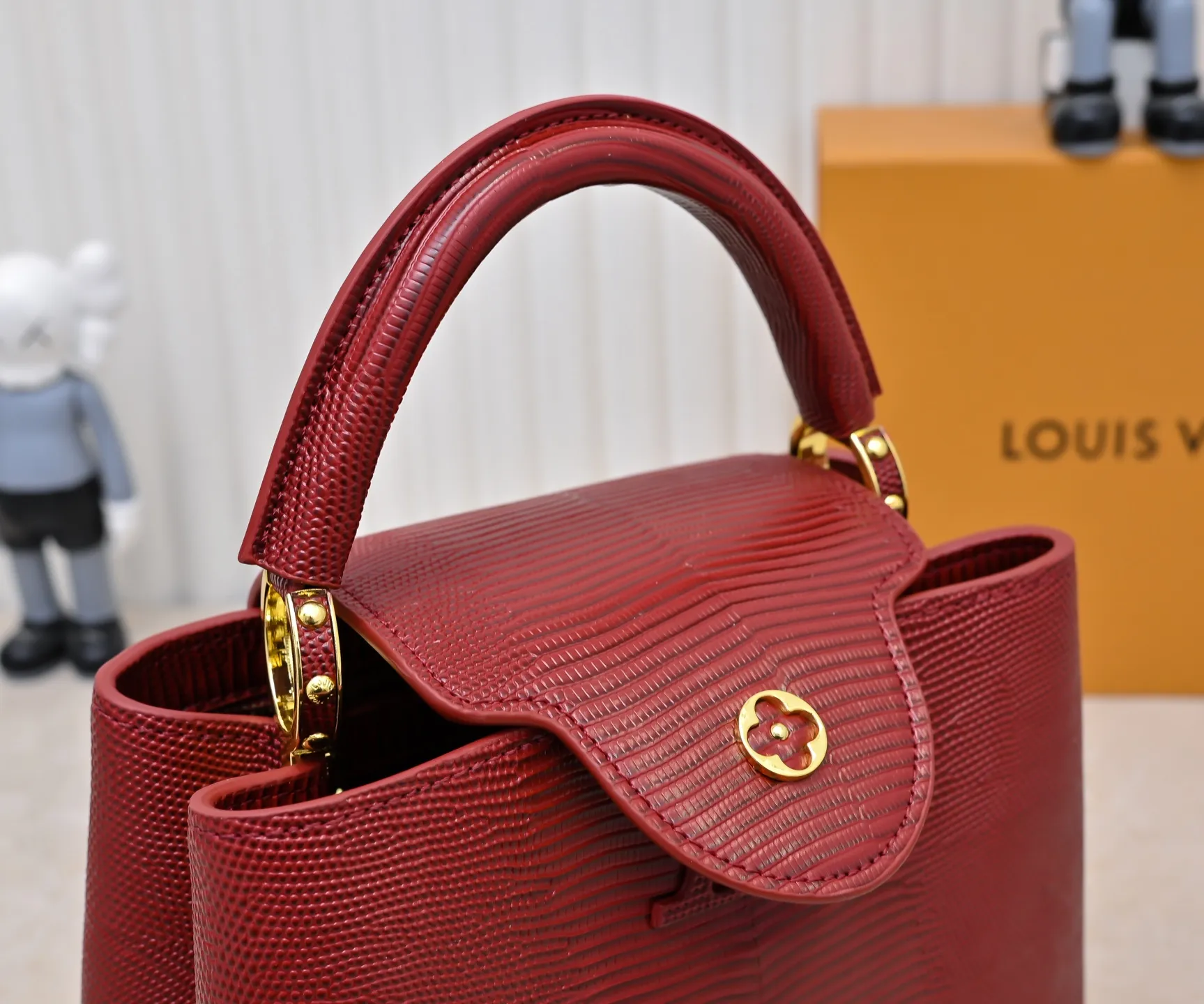 Top-quality original P420 Guangzhou-made M99528 maroon lizard skin gold buckle CapucinesBB handbag exquisitely combines graceful lizard skin outer layer, delicate sheepskin lining and luster metal parts. The iconic flap makes two styles fashionable. The LV logo can be read on the inside and Monogram flowers bloom on the outside. It can light up an eye-catching corner for evening occasions and add a personalized atmosphere to the wardrobe. Shine gorgeous style in day and night occasions.  Detailed features 27 x 18 x 9 cm (length x height x width)