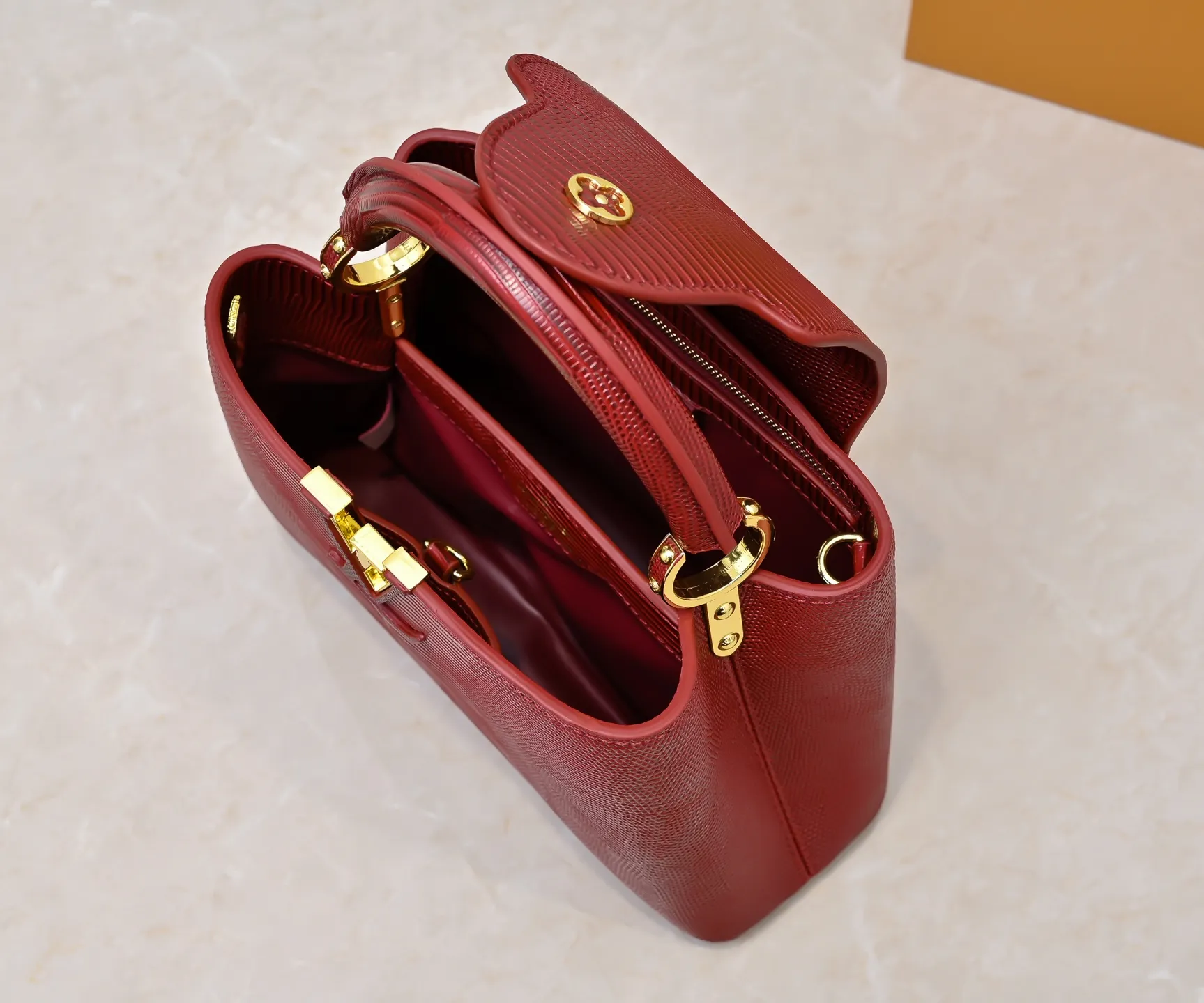 Top-quality original P420 Guangzhou-made M99528 maroon lizard skin gold buckle CapucinesBB handbag exquisitely combines graceful lizard skin outer layer, delicate sheepskin lining and luster metal parts. The iconic flap makes two styles fashionable. The LV logo can be read on the inside and Monogram flowers bloom on the outside. It can light up an eye-catching corner for evening occasions and add a personalized atmosphere to the wardrobe. Shine gorgeous style in day and night occasions.  Detailed features 27 x 18 x 9 cm (length x height x width)