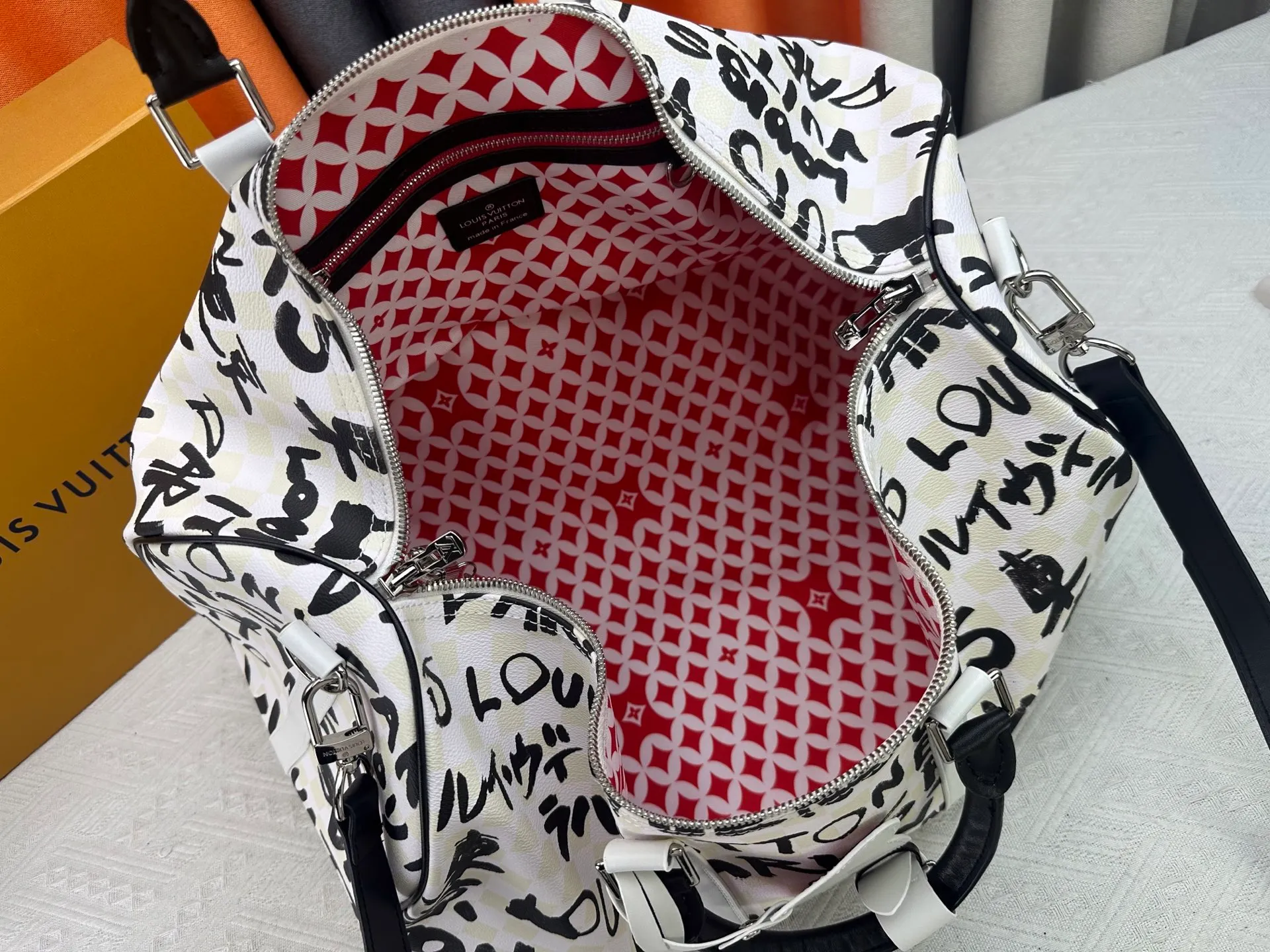 P420 Guangzhou goods N40804 M41416 Tokyo 1 style Keepall Bandoulière 50 travel bag is jointly created by Japanese designers Nigo and Pharrell Williams. It is laid out with elegant plaid on the cow leather, and then writes eye-catching words in French and Japanese. A cotton lining pattern bears witness to Nigo's artistic vision, and a removable LV Dynasty nameplate highlights the brand's identity. 29 cm