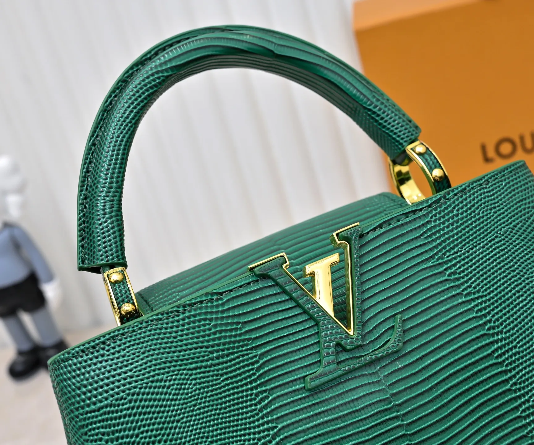 Top-quality original P420 Guangzhou-made M99528 green lizard skin gold buckle CapucinesBB handbag exquisitely combines elegant lizard skin outer layer, delicate sheepskin lining and glossy metal parts. The iconic flap makes two styles fashionable. The LV logo can be read on the inside and Monogram flowers bloom on the outside. It can light up an eye-catching corner for evening occasions and add a personalized atmosphere to the wardrobe. Shine gorgeous style in day and night occasions.  Detailed features 27 x 18 x 9 cm (length x height x width)