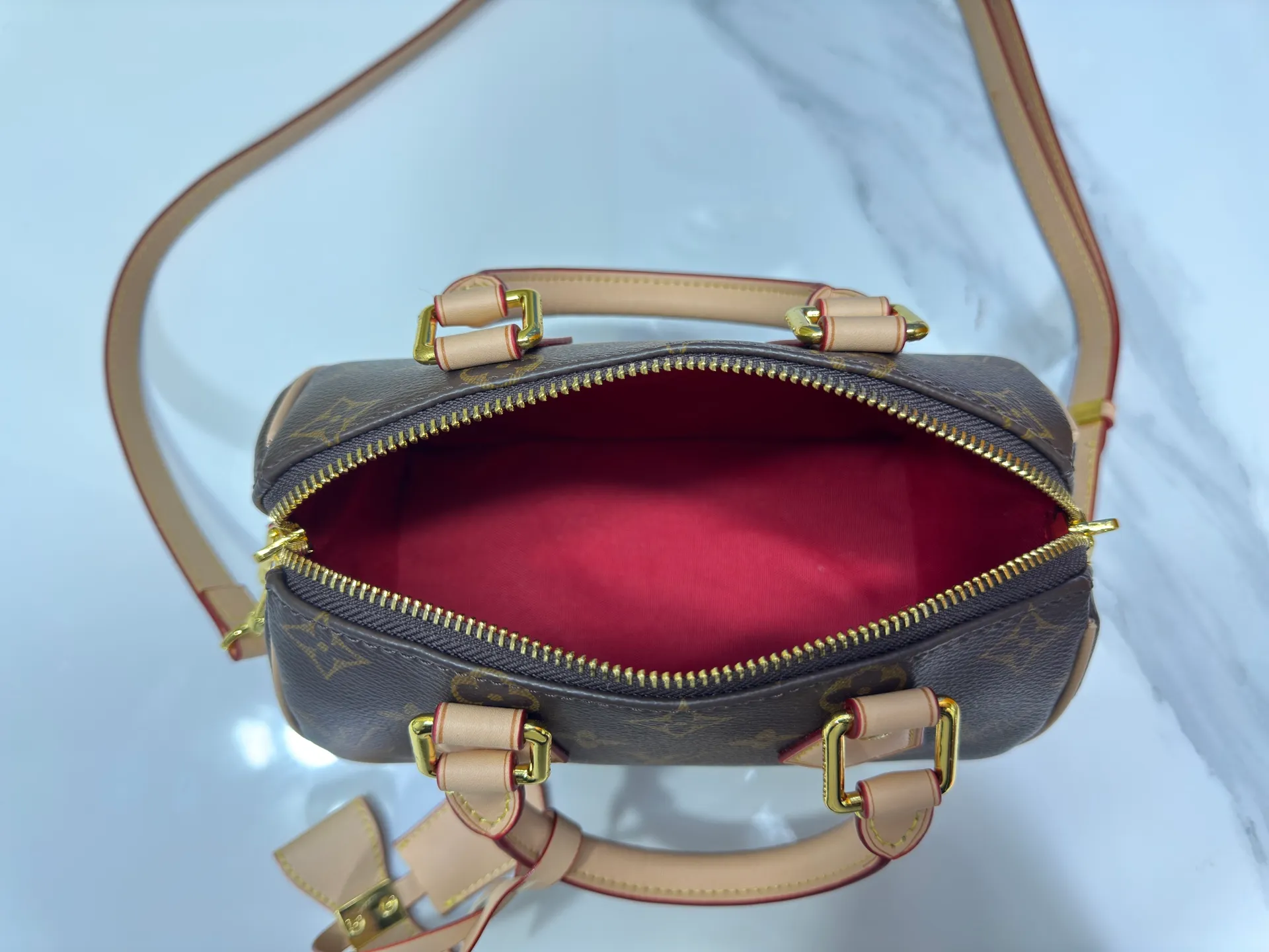 P260 Upgraded from the original version, this M46234 M46222 Speedy Bandoulière 20 handbag is made of soft coated canvas, with the full-length Monogram pattern traced in colorful rainbow tones, highlighting the smart style of the Louis Vuitton x Murakami reissue series. The Toron handle and detachable shoulder strap are constructed of cow leather, the metal corners recall classic luggage elements, and the bow-shaped key bag and padlock add brand touches. Dimensions: 20.5 x 13.5 x 12.0 cm (length x height x width)