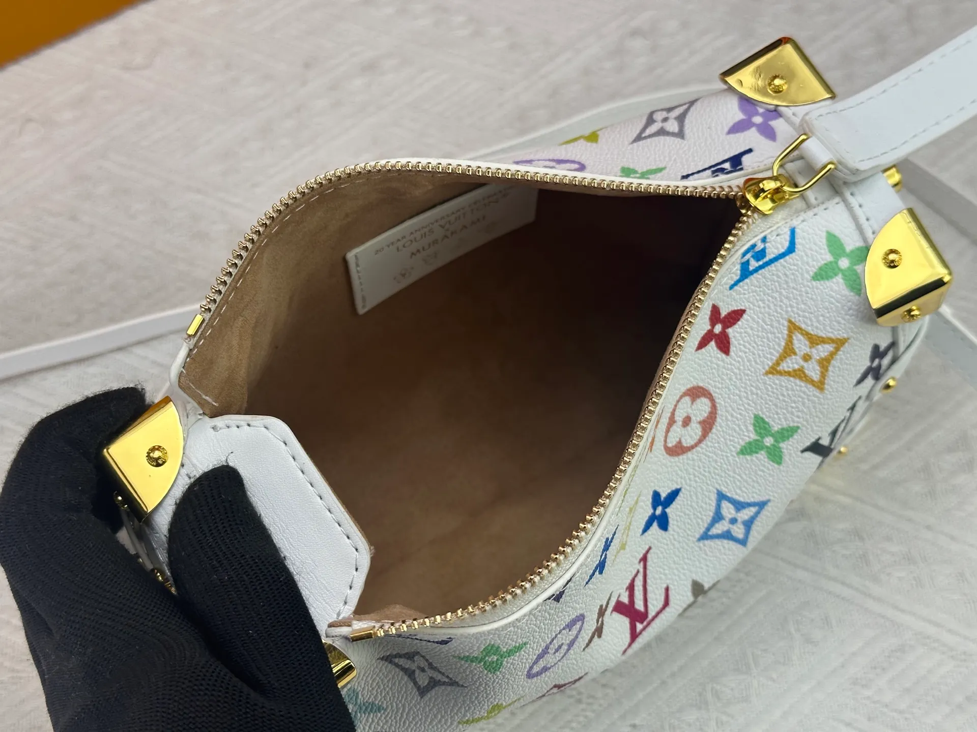 P280 M14046 M46358 Black Tricolor White Tricolor This Side Trunk medium handbag uses a humorous Monogram pattern to express the smart style of the Louis Vuitton × Murakami reissue series. It is made of soft cow leather with reinforced metal corners and the iconic S-lock lock, which can easily accommodate daily needs. The square shape is a nod to the brand's classic luggage, and the removable studded handle and shoulder strap allow for flexible carrying. Size: 23.5x16x8.5cm