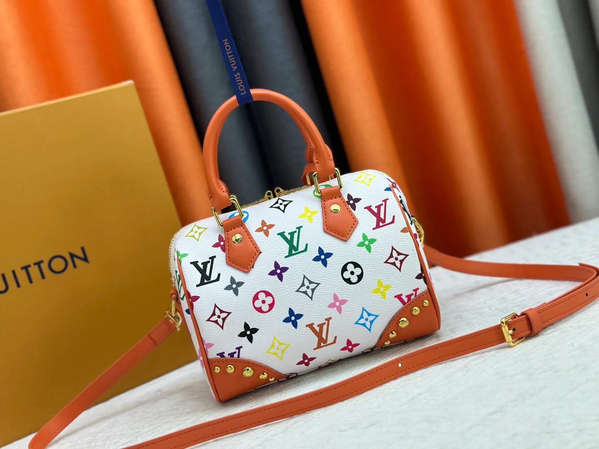P260 upgraded original M58953 M46234 M46222 Speedy Bandoulière 20 handbag is made of soft coated canvas, and the full-length Monogram pattern is traced in colorful rainbow tones, highlighting the smart style of the Louis Vuitton x Murakami reissue series. The Toron handle and detachable shoulder strap are constructed of cow leather, the metal corners recall classic luggage elements, and the bow-shaped key bag and padlock add brand touches. Dimensions: 20.5 x 13.5 x 12.0 cm (length x height x width)