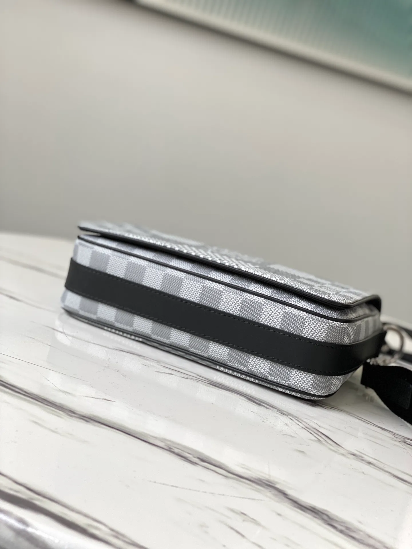 💰840 Top Original N50014 Silver White This Studio messenger bag is made of Damier Graphite 3D canvas, telling the modern renewal of the brand's legendary plaid. The neat structure includes ample functional space, and the detachable shoulder strap is subtly embellished with the brand logo, defining a trendy new way to store travel items. Dimensions: 23.5 x 14 x 5 cm