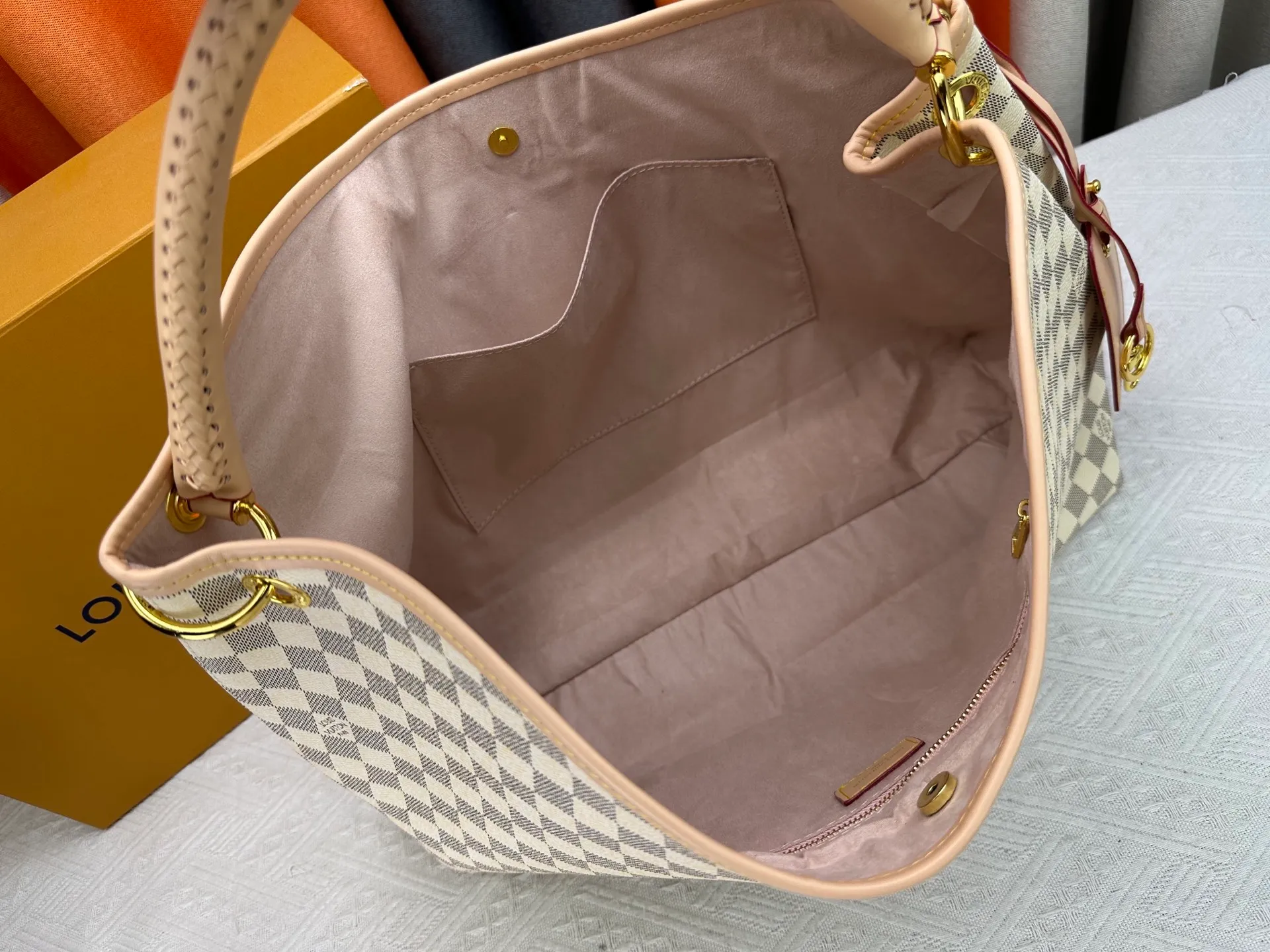 P300 upgrades the original M25877 Again bag, a new interpretation of the iconic Artsy design first launched in 2010, now more flexible, more iconic and more refined. Rooted in LV’s DNA, this bag pays homage to Louis Vuitton’s craftsmanship with its classic Monogram canvas base, hand-woven handles and customizable name tag. It's spacious enough to hold a laptop and opens to reveal multiple pockets. Gold hooks can be used to hang playful accessories! ! Size:50x30x15.5CM