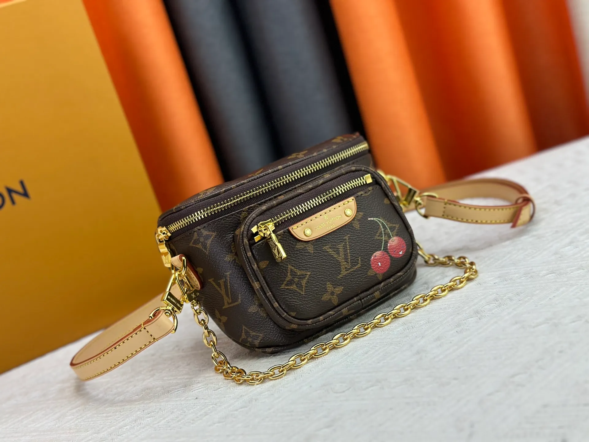 P240 M82208 M00130 M82335 This Mini Bumbag handbag comes from the LV Gradient series. The Monogram embossing of Monogram Empreinte leather renders the gradient midsummer color. The on-trend construction features a zipped main compartment and a front pocket with a Louis Vuitton leather label. With the detachable chain and detachable and adjustable shoulder strap, it can be worn as a shoulder or cross-body bag. Dimensions: 17x12x9.5 cm