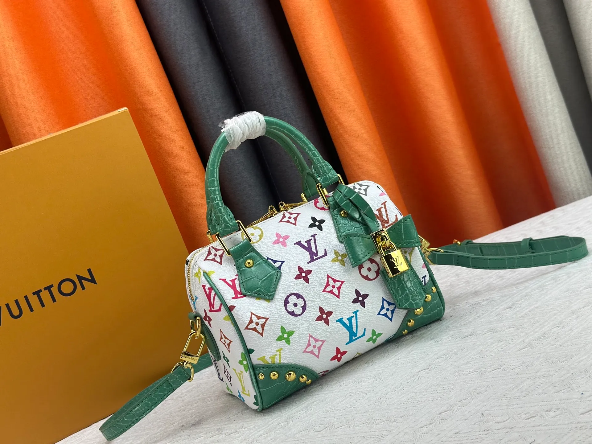 P260 Upgraded original crocodile pattern M13365 M58953 M46234 M46222 Speedy Bandoulière 20 handbag is made of soft coated canvas, and the full-length Monogram pattern is traced in colorful rainbow tones, highlighting the smart style of the Louis Vuitton x Murakami reissue series. The Toron handle and detachable shoulder strap are constructed of cow leather, the metal corners recall classic luggage elements, and the bow-shaped key bag and padlock add brand touches. Dimensions: 20.5 x 13.5 x 12.0 cm (length x height x width)