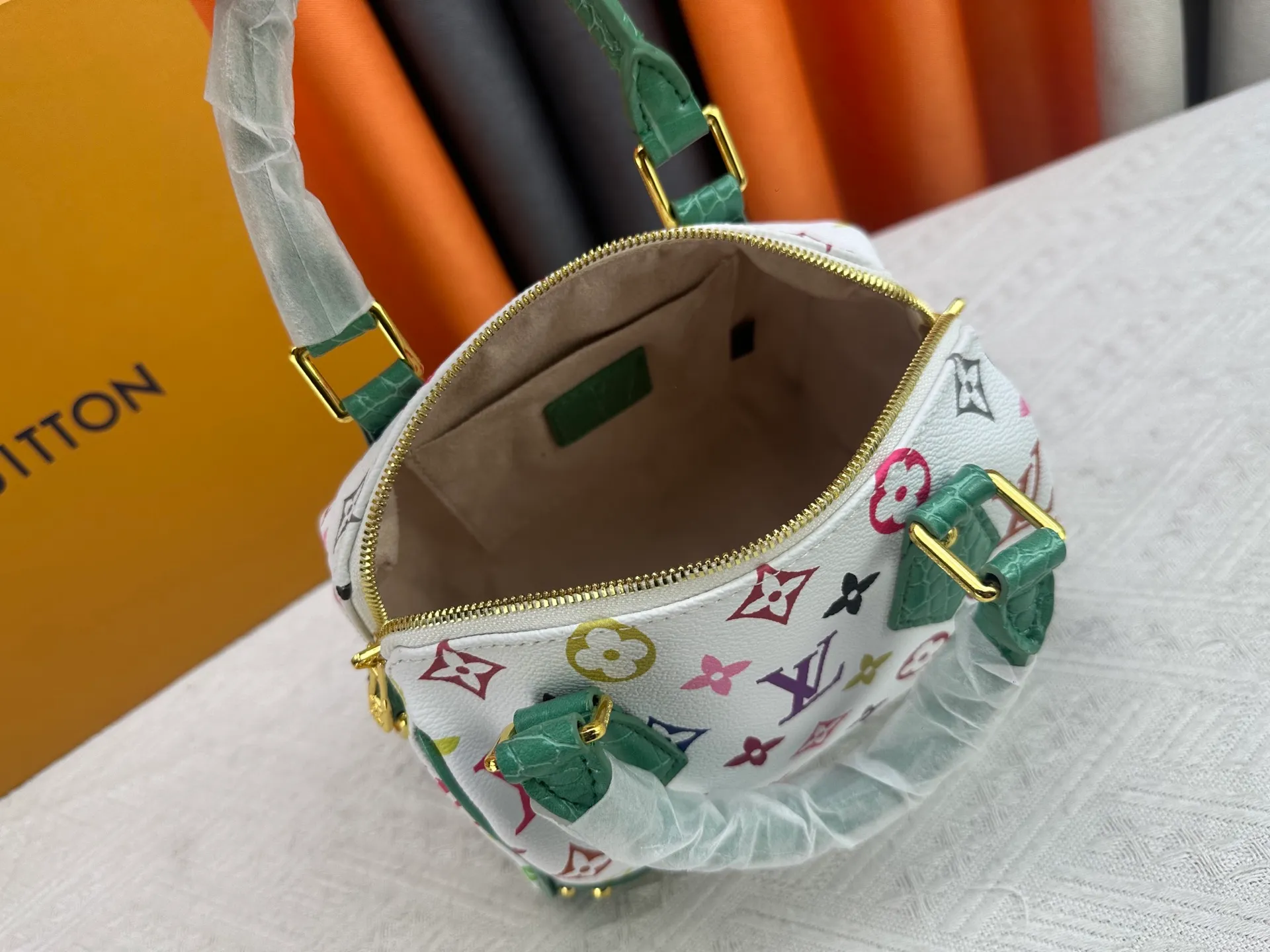 P260 Upgraded original crocodile pattern M13365 M58953 M46234 M46222 Speedy Bandoulière 20 handbag is made of soft coated canvas, and the full-length Monogram pattern is traced in colorful rainbow tones, highlighting the smart style of the Louis Vuitton x Murakami reissue series. The Toron handle and detachable shoulder strap are constructed of cow leather, the metal corners recall classic luggage elements, and the bow-shaped key bag and padlock add brand touches. Dimensions: 20.5 x 13.5 x 12.0 cm (length x height x width)