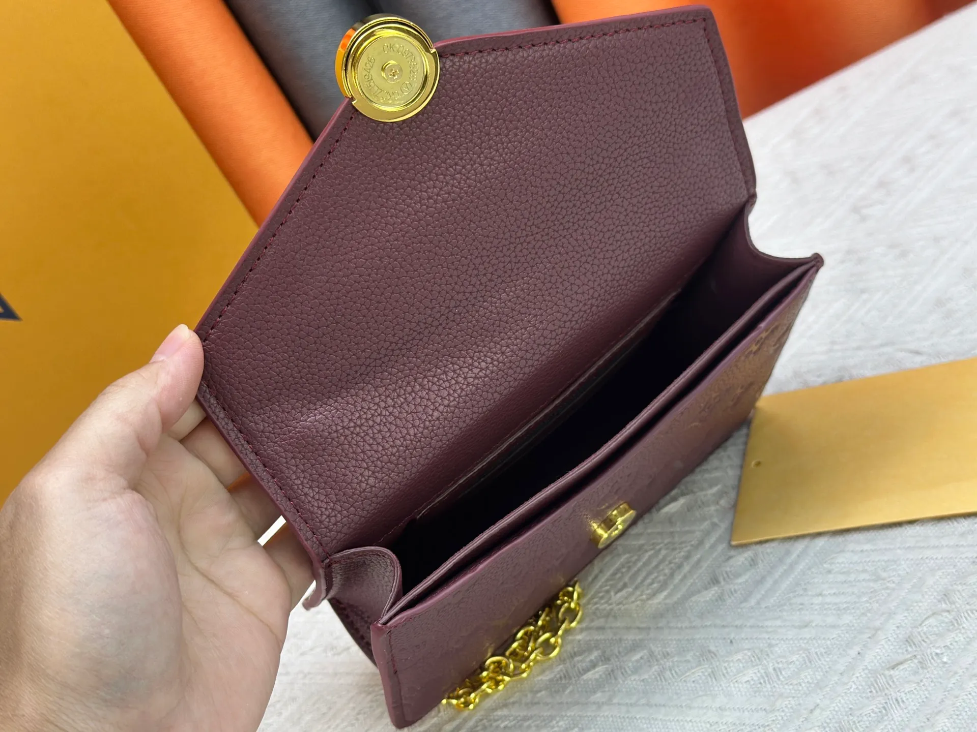 P220 M13569 black M13570 gray M25814 burgundy (chain/embossed) [Portefeuille chaîne Rosy] This Rosy chain wallet is both fashionable and practical, adding a modern spirit to the Monogram Empreinte series. It has an elegant LV circle and a V-shaped flap, two hallmarks of the house. The magnetic closure reveals a surprise Monogram flower, as well as three card slots and a flat interior pocket. The sliding chain allows you to wear it crosswise or over the shoulder.  Dimensions: 19.5 x 13.5 x 6.5 cm