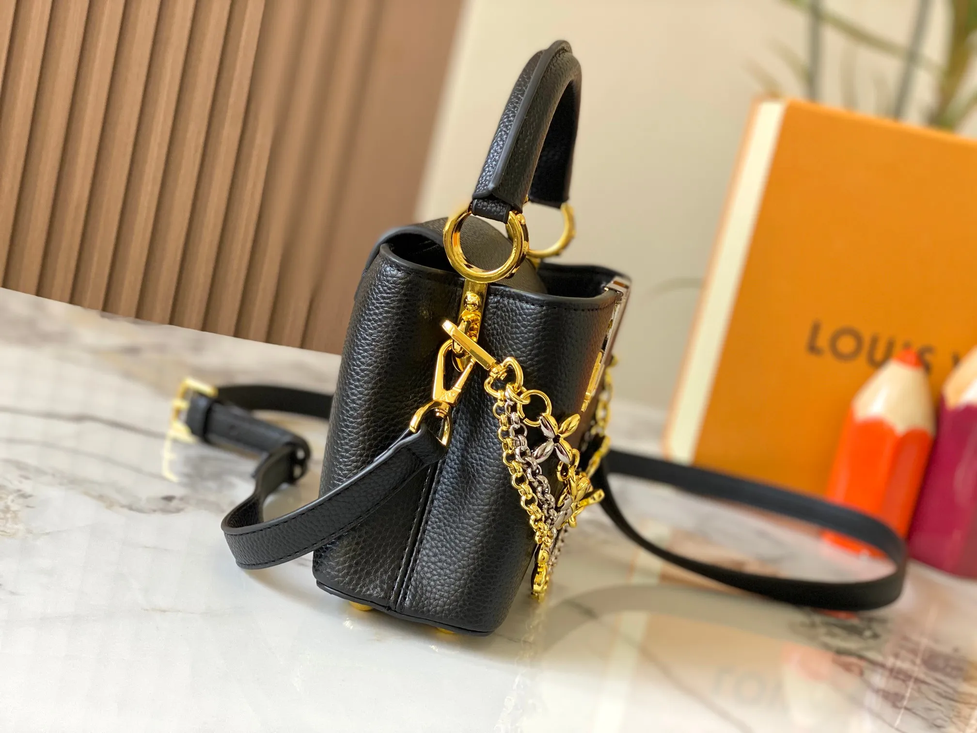 P480 [Guangzhou top quality original version] M26351 Black Gold This modern version of Capucines mini is made of timeless Taurillon leather and equipped with a jewelry-inspired Infinity chain. The bag is decorated with double galvanized metal parts, including the iconic Monogram floral pattern, and the LV Initials logo created with sunburst technology, creating a sundial-like light and shadow effect. The bag has multiple pockets and a detachable shoulder strap, allowing it to be carried on one shoulder or across the body. 14 x 8 x 21 cm (height x width x length)