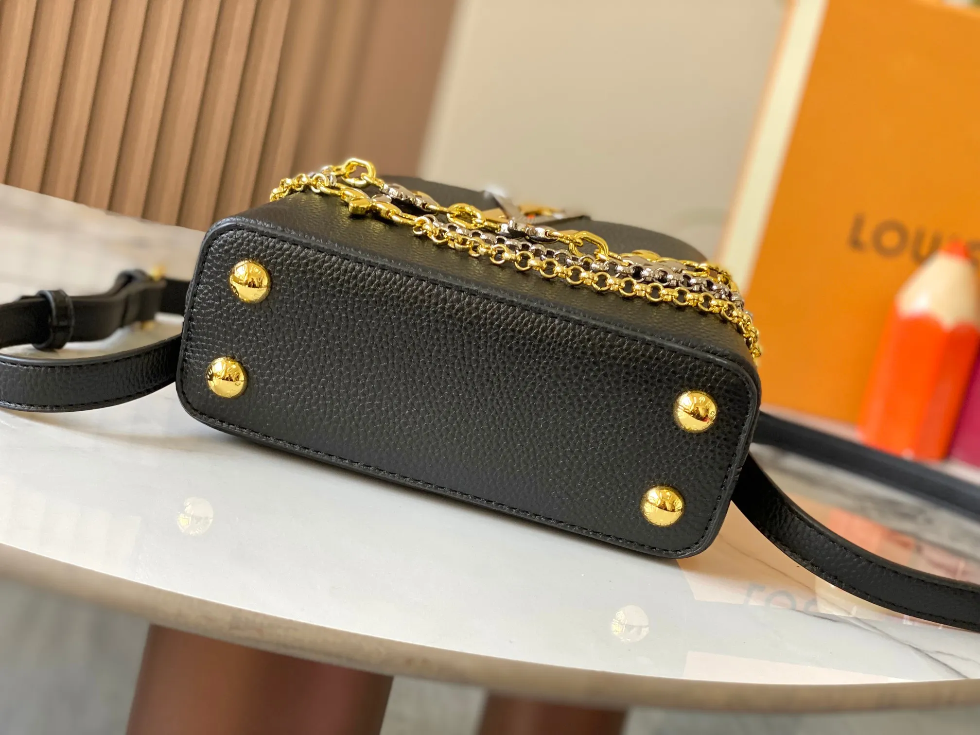 P480 [Guangzhou top quality original version] M26351 Black Gold This modern version of Capucines mini is made of timeless Taurillon leather and equipped with a jewelry-inspired Infinity chain. The bag is decorated with double galvanized metal parts, including the iconic Monogram floral pattern, and the LV Initials logo created with sunburst technology, creating a sundial-like light and shadow effect. The bag has multiple pockets and a detachable shoulder strap, allowing it to be carried on one shoulder or across the body. 14 x 8 x 21 cm (height x width x length)