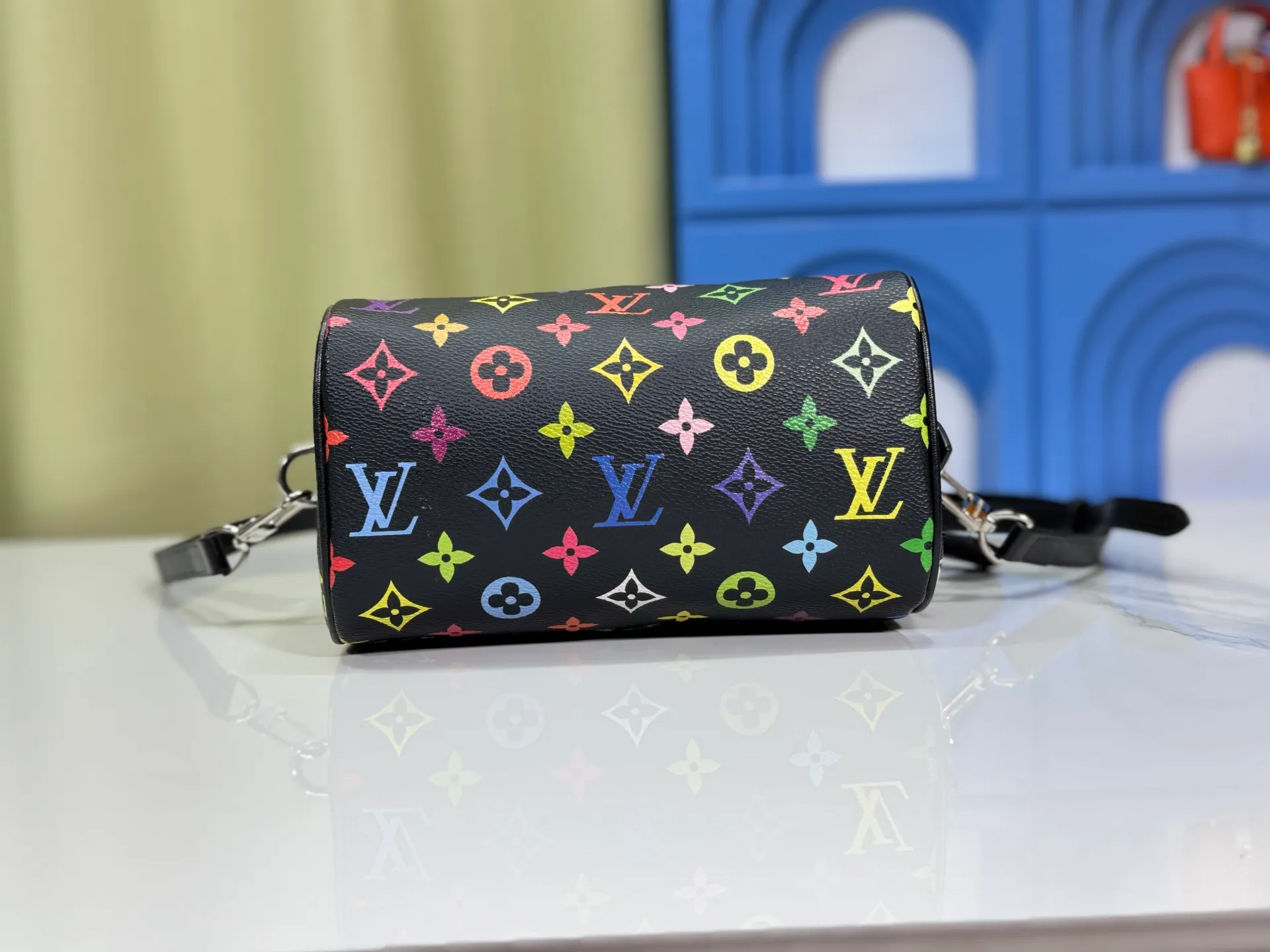 P260 Upgraded from the original version, this M46234 M46222 Speedy Bandoulière 20 handbag is made of soft coated canvas, with the full-length Monogram pattern traced in colorful rainbow tones, highlighting the smart style of the Louis Vuitton x Murakami reissue series. The Toron handle and detachable shoulder strap are constructed of cow leather, the metal corners recall classic luggage elements, and the bow-shaped key bag and padlock add brand touches. Dimensions: 20.5 x 13.5 x 12.0 cm (length x height x width)