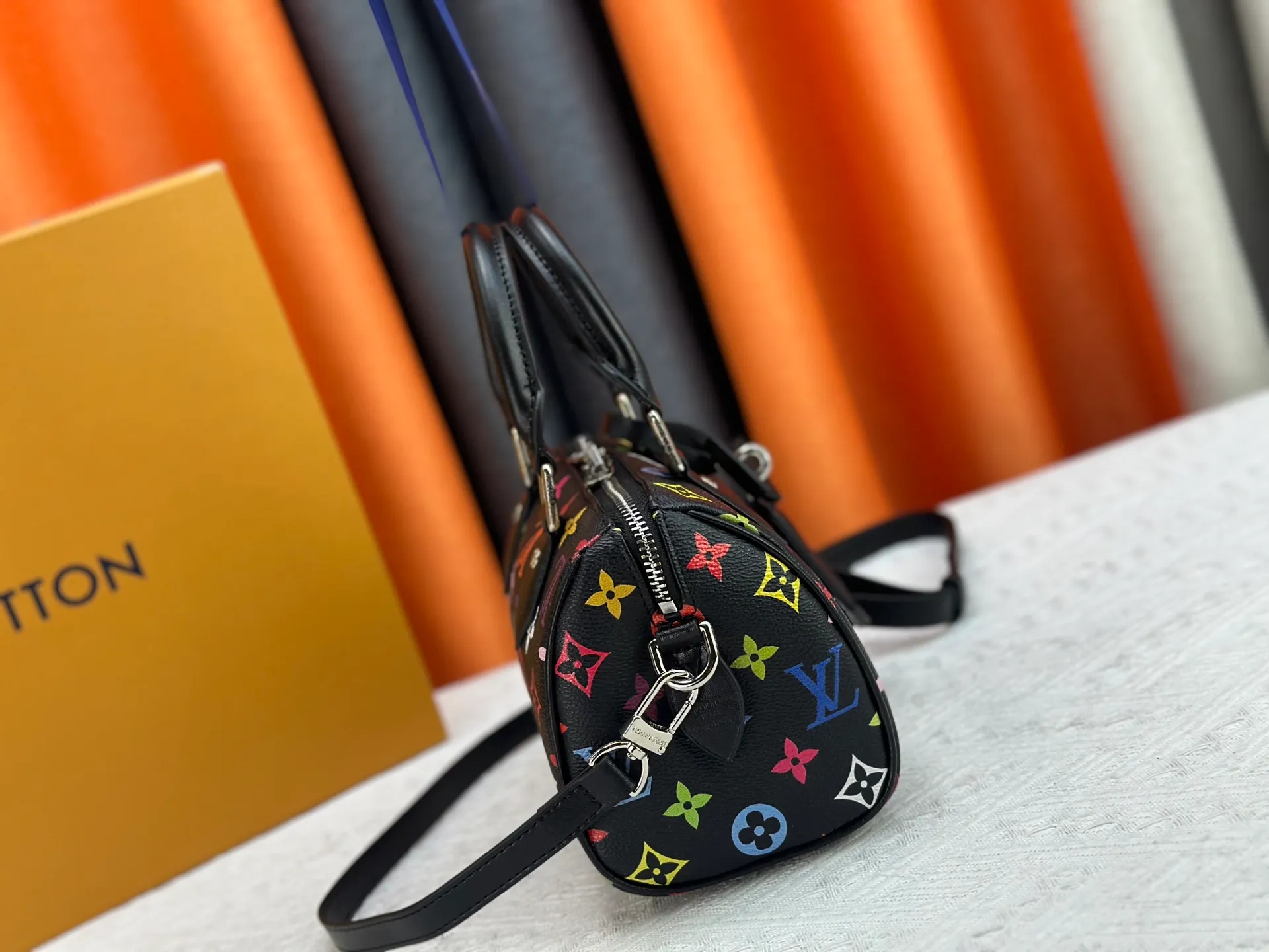 P260 Upgraded from the original version, this M46234 M46222 Speedy Bandoulière 20 handbag is made of soft coated canvas, with the full-length Monogram pattern traced in colorful rainbow tones, highlighting the smart style of the Louis Vuitton x Murakami reissue series. The Toron handle and detachable shoulder strap are constructed of cow leather, the metal corners recall classic luggage elements, and the bow-shaped key bag and padlock add brand touches. Dimensions: 20.5 x 13.5 x 12.0 cm (length x height x width)