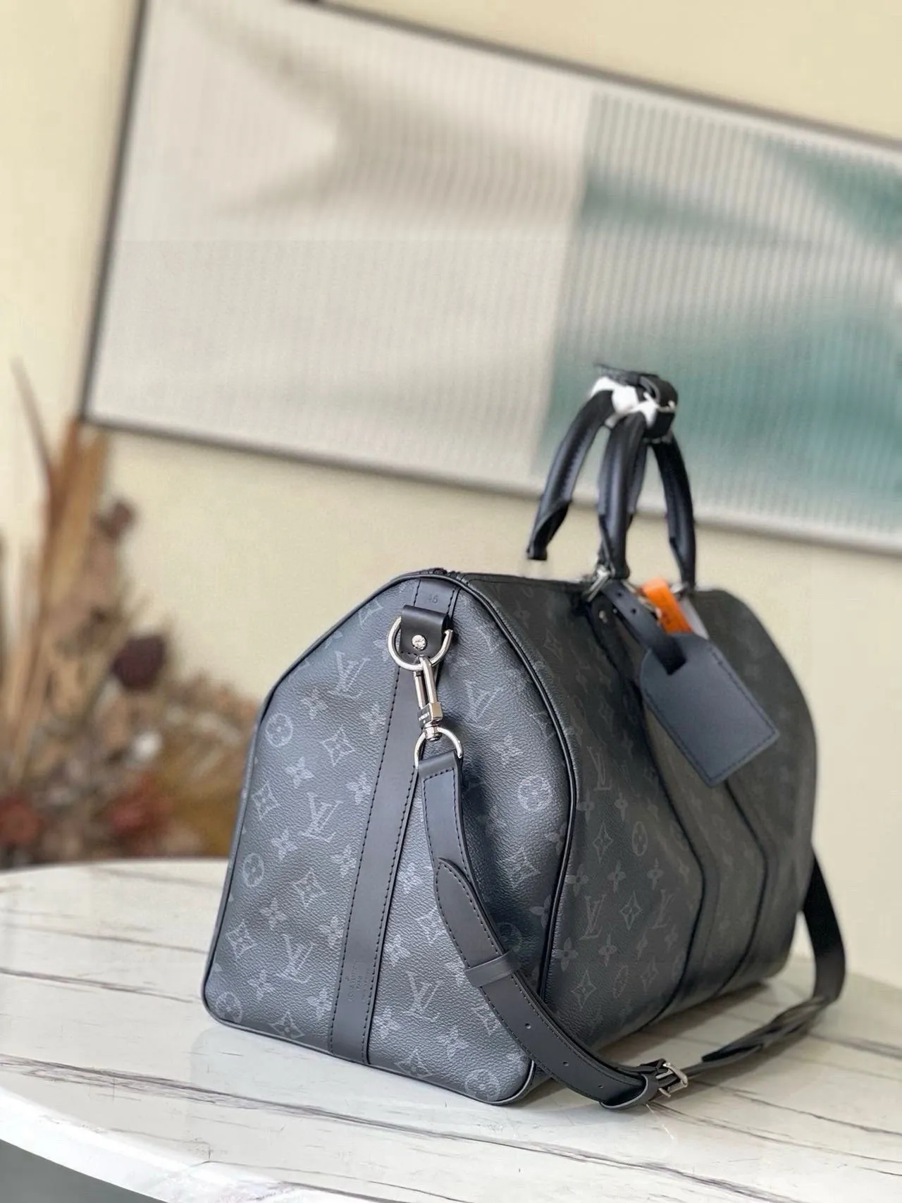 💰1040 (55 size) top original single M40605 black flower, spacious capacity, flexible use. Durable, safe and reliable. Fashionable style, mature and stable. Features a secure double zipper and padlock, making it perfect for business or pleasure. Size: 55x 31× 26cm
