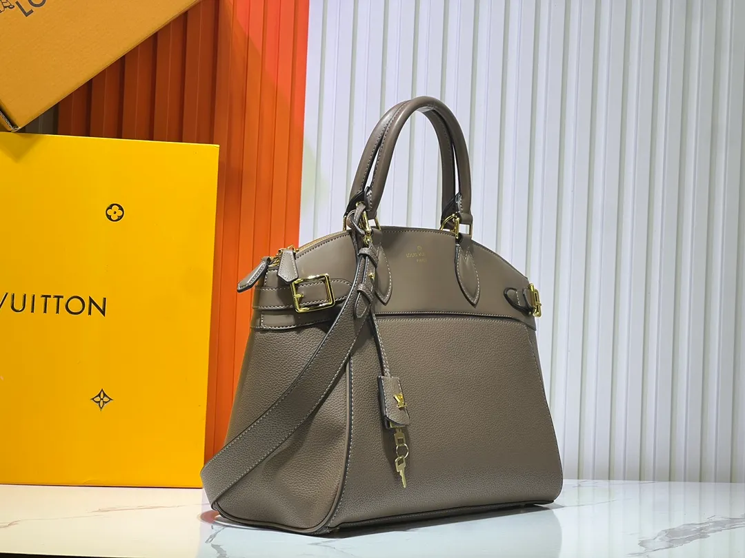 Batch 340💰M11214 green M22914 black M22925 brown M23061 off-white M22927 taupe. Sophisticated and functional, the Lock It MM bag is crafted in fine grained Taurillon leather and smooth calfskin, with gold-finish buckles and hardware. Signature House touches include padlocks, key bells and hot-stamped Louis Vuitton signatures. Featuring an articulated top handle and removable strap, this tote offers a variety of carrying options. 36x29x15 cm (LxHxW) Black Taurillon leather, smooth calfskin semi-leather trim Microfiber lining Gold hardware 2 square buckles padlock key bell External pockets 2 internal flat pockets Internal zipped pocket with flat pockets 5 protective metal studs Strap: removable, adjustable Strap drop: 45.0 cm Maximum strap drop: 51.0 cm
