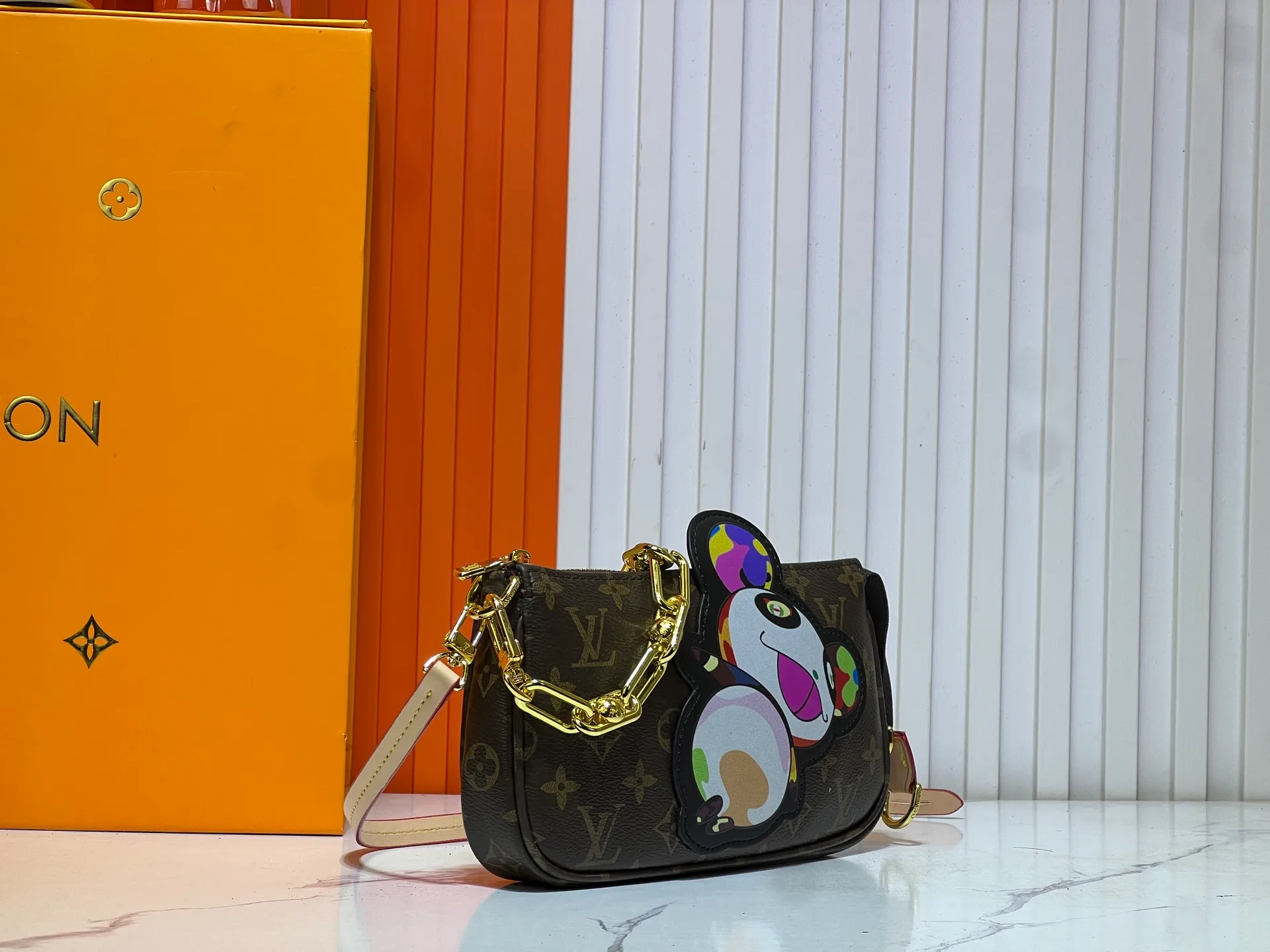 Batch 240💰M13440 This Pochette Accessoires handbag is made of Monogram coated canvas, injecting lively personality into the Louis Vuitton x Murakami reissue series. The colorful panda image created by the artist renews the classic silhouette, and the zipper design allows for secure storage of daily items. The cowhide leather shoulder strap and dazzling chain are both detachable, allowing for a variety of carrying options. Size: 22X13X4cm