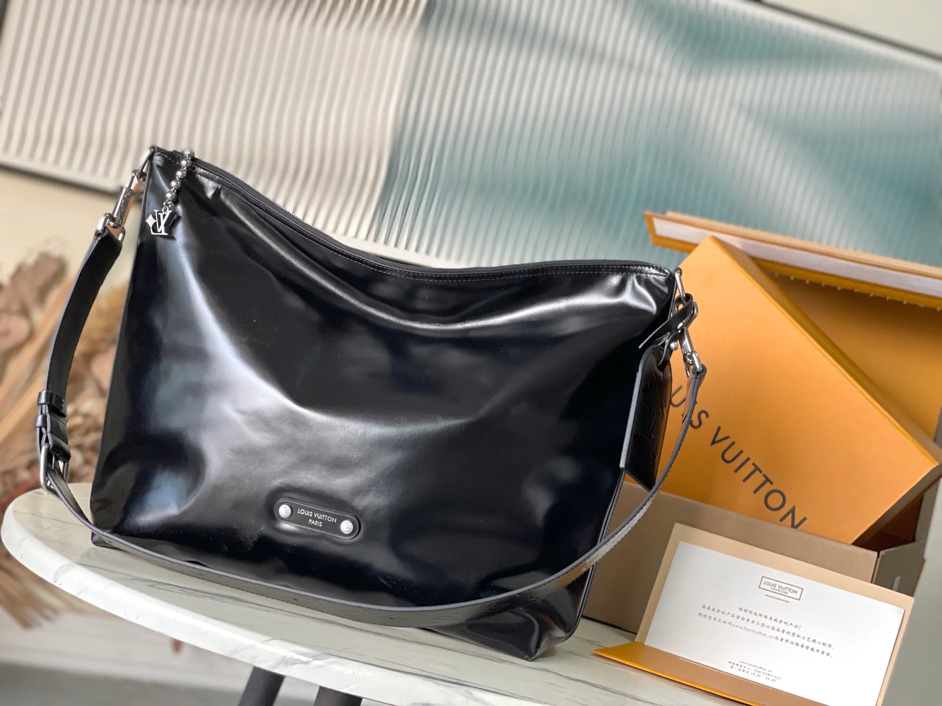 💰1280 (top-grain leather) top original order M13986 This Vagabond Hobo handbag is made of glossy soft cow leather to create an ergonomic and close-fitting silhouette. Whether it is worn cross-body or on the shoulder, it can show its cool style. The metal zipper enables smooth opening and closing, and the bead chain cleverly connects the zipper puller and V letter decoration. Dimensions: 35×12×38 cm