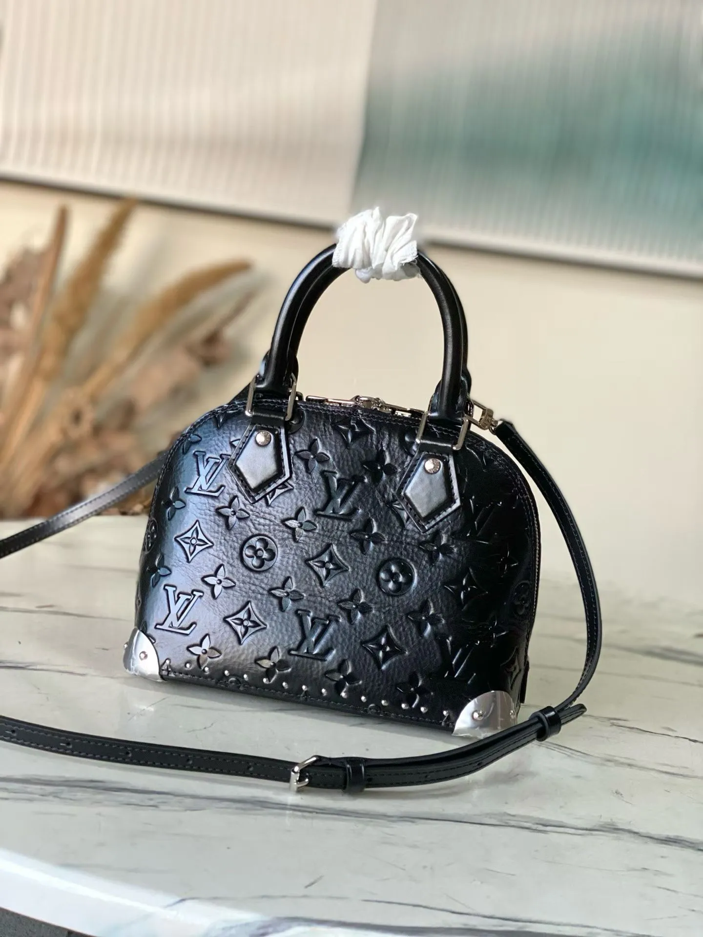 💰1140 (top layer leather) top original order M27812 This Alma BB handbag displays the brand’s Monogram Saga logo, exuding a retro atmosphere and rock style. It's made from cow leather and trimmed with cow leather, and has a chunky chain and signature S-lock that complements the metal corners. There are a variety of carrying methods, and the internal space can accommodate daily needs. Dimensions: 22 × 19 × 11 cm