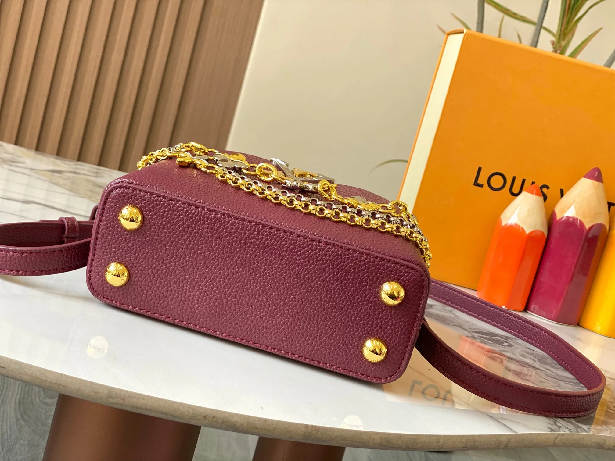 P480 [Guangzhou top quality original version] M26351 Bordeaux Red This modern version of Capucines mini is made of timeless Taurillon leather and equipped with a jewelry-inspired Infinity chain. The bag is decorated with double galvanized metal parts, including the iconic Monogram floral pattern, and the LV Initials logo created with sunburst technology, creating a sundial-like light and shadow effect. The bag has multiple pockets and a detachable shoulder strap, allowing it to be carried on one shoulder or across the body. 14 x 8 x 21 cm (height x width x length)