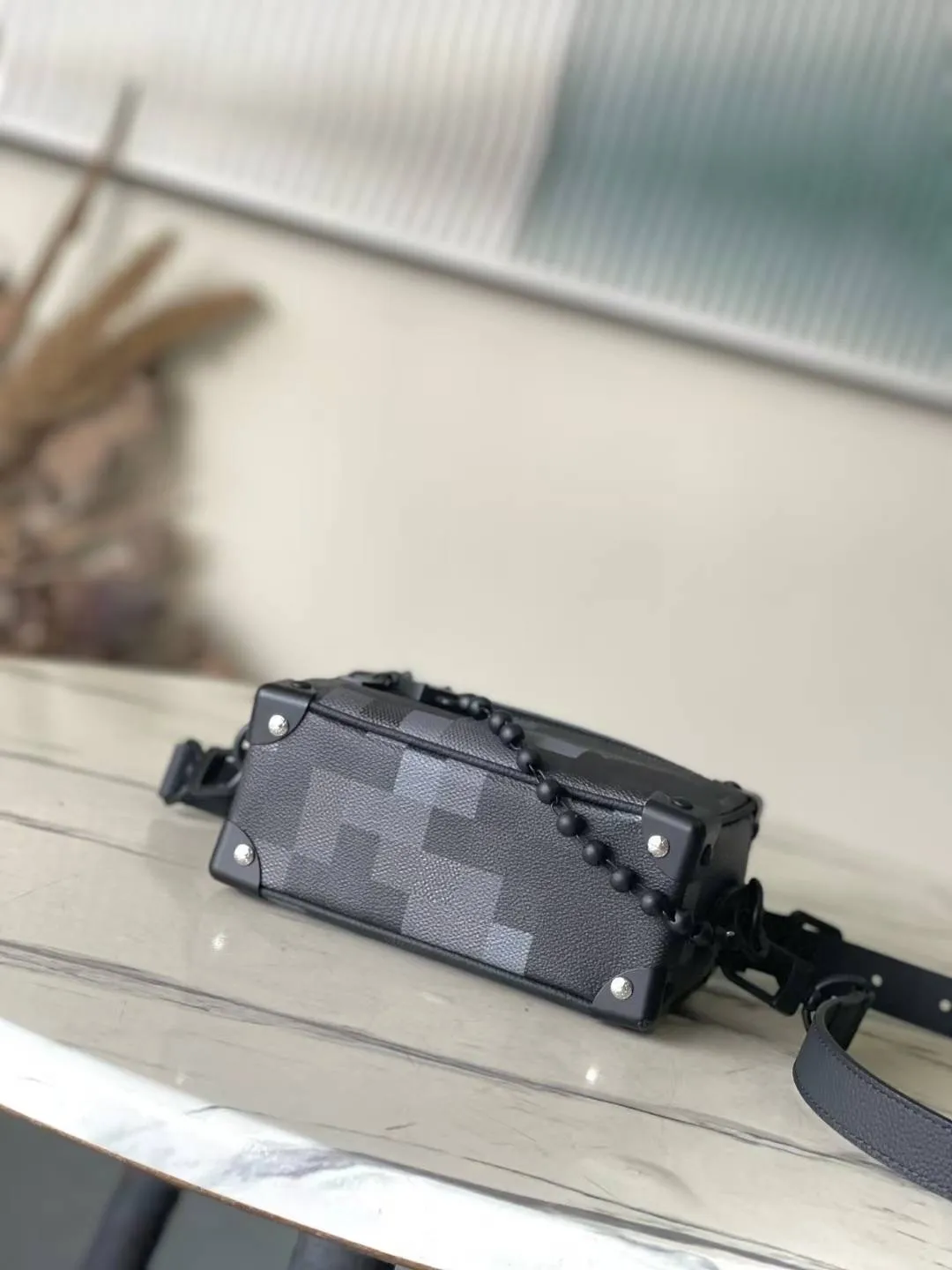 💰1180 Top Original Order M14922 This Mini Soft Trunk handbag is made of Damoflage Black coated canvas with cow leather trim. The compact body is decorated with the pixelated Damier pattern written by Pharrell Wiliams to fully interpret the modern style. The rolled leather top handle and detachable and adjustable shoulder strap provide a variety of carrying options. Dimensions: 18.5 × 13 × 8 cm