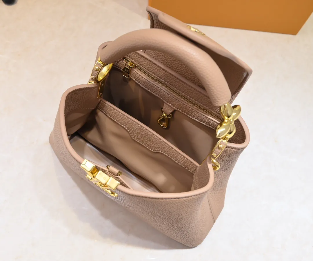 The upgraded version of the P460 M24698 Capucines BB handbag is made of Taurillon cow leather decorated with shiny metal parts, and the LV letters are written in 3D strokes. Metal Monogram flowers bloom quietly on the rolled leather handle, subtly proving the brand's exquisite craftsmanship. The detachable and adjustable leather shoulder strap allows for comfortable shoulder carrying. Detailed features 26.5 x17.5 x9 cm